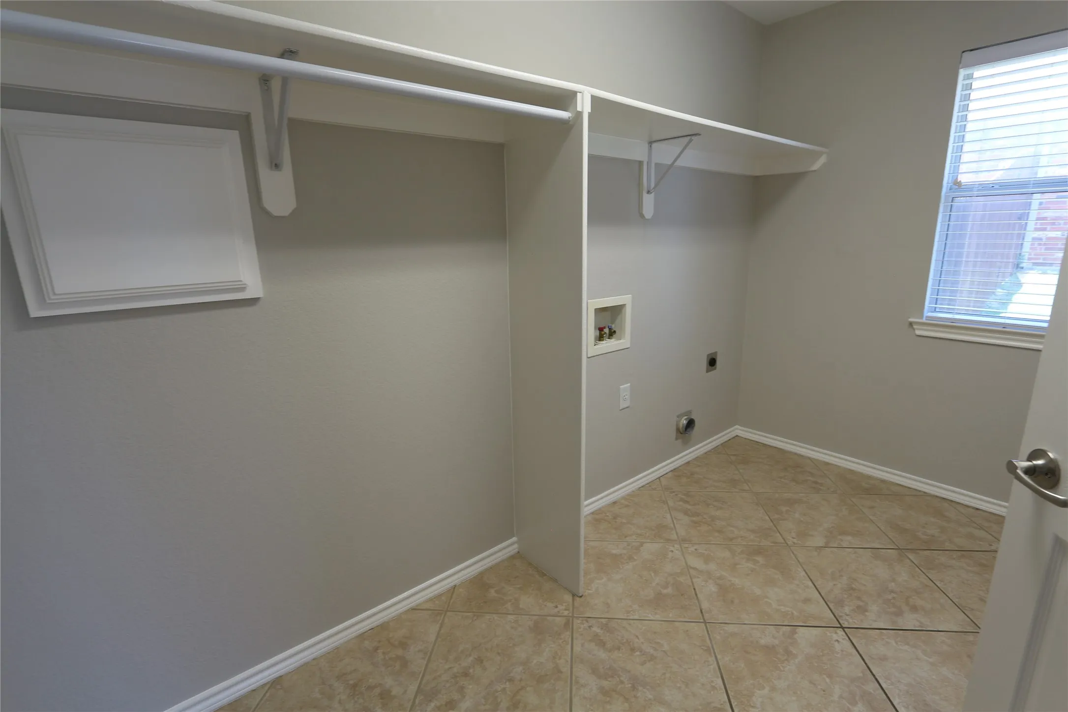 Laundry area featuring hookup for a washing machine, hookup for an electric dryer, and light tile floors