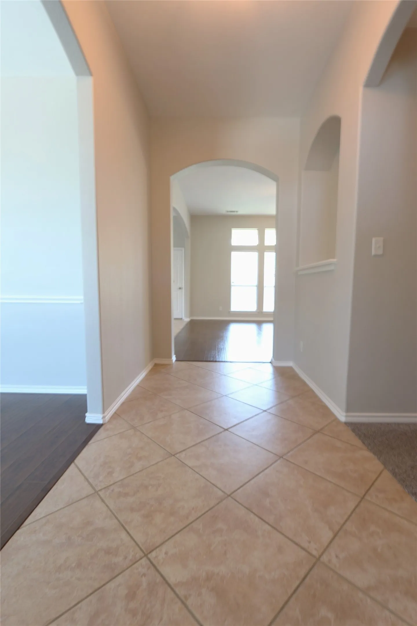 Hallway featuring light tile floors