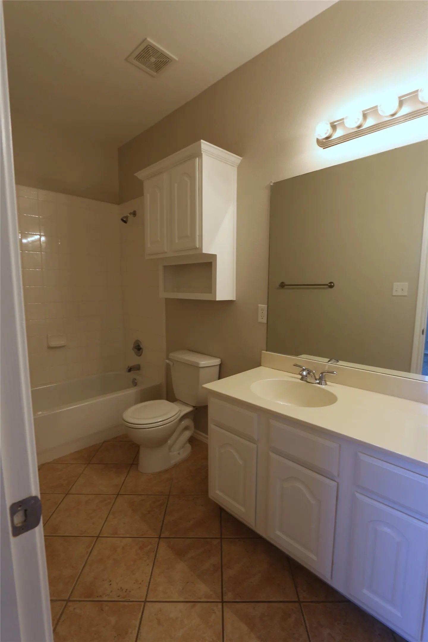 Full bathroom featuring tile flooring, tiled shower / bath combo, vanity, and toilet