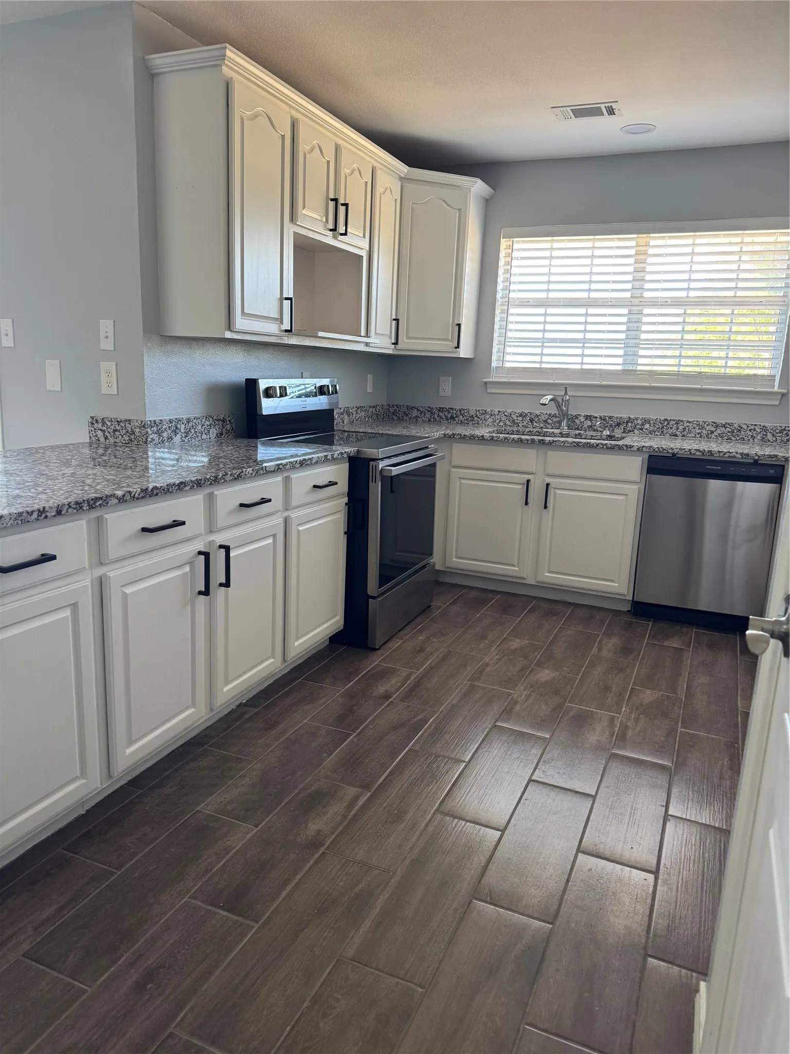 Kitchen featuring white cabinetry, stainless steel appliances