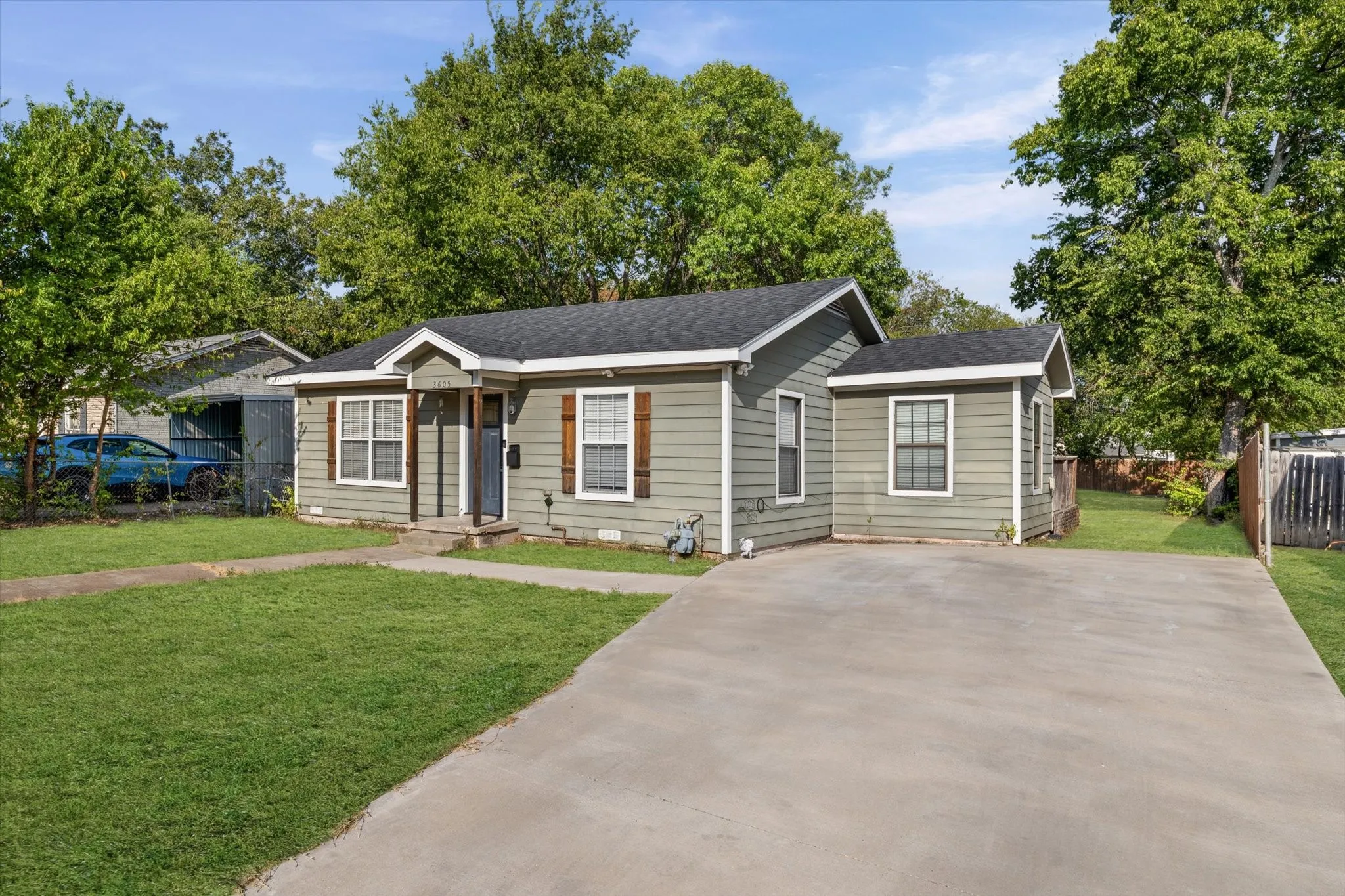 Siding exterior with white trim, wood shutters, and dark roofing