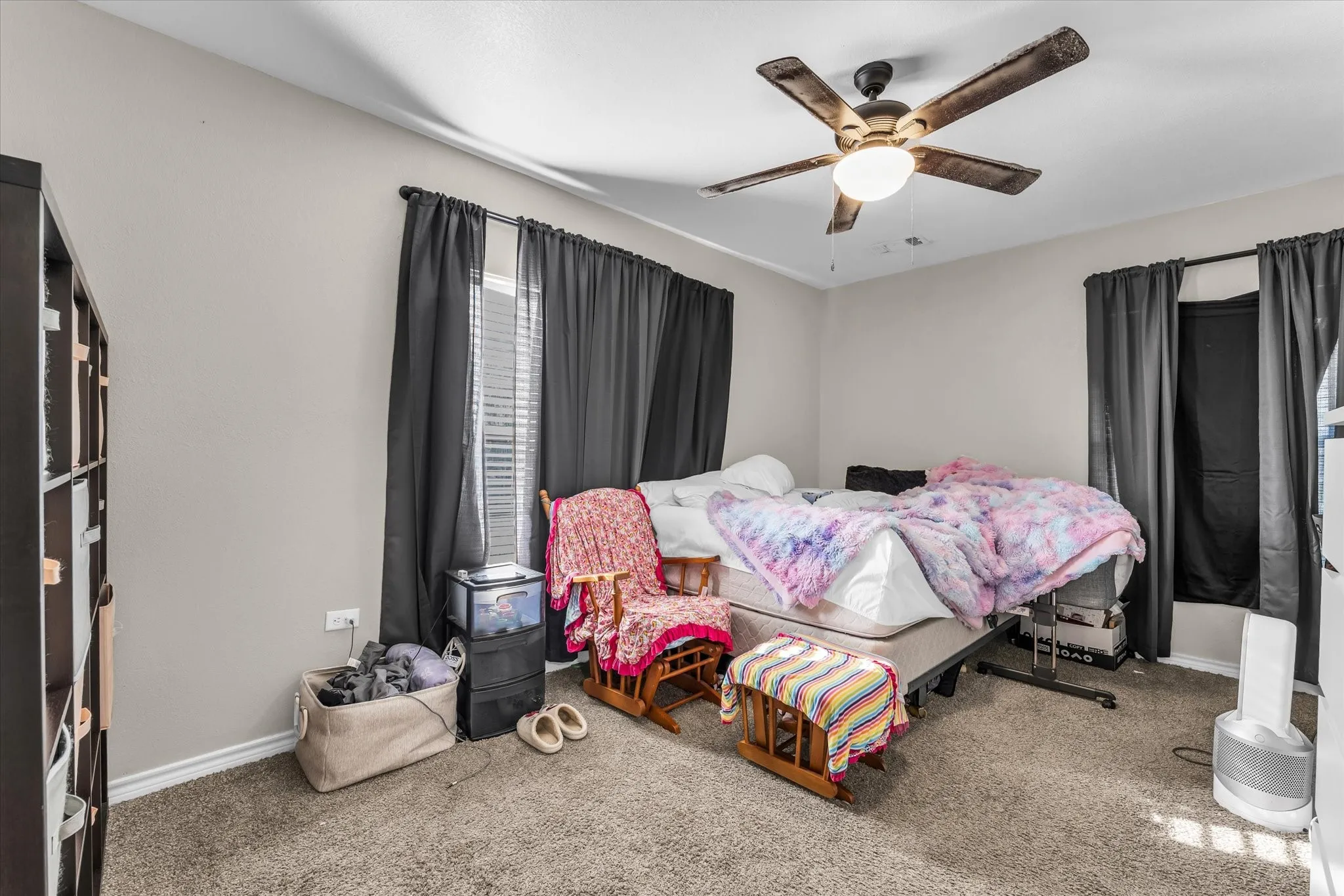 Carpeted flooring, neutral wall tones, and an integrated ceiling fan with lighting