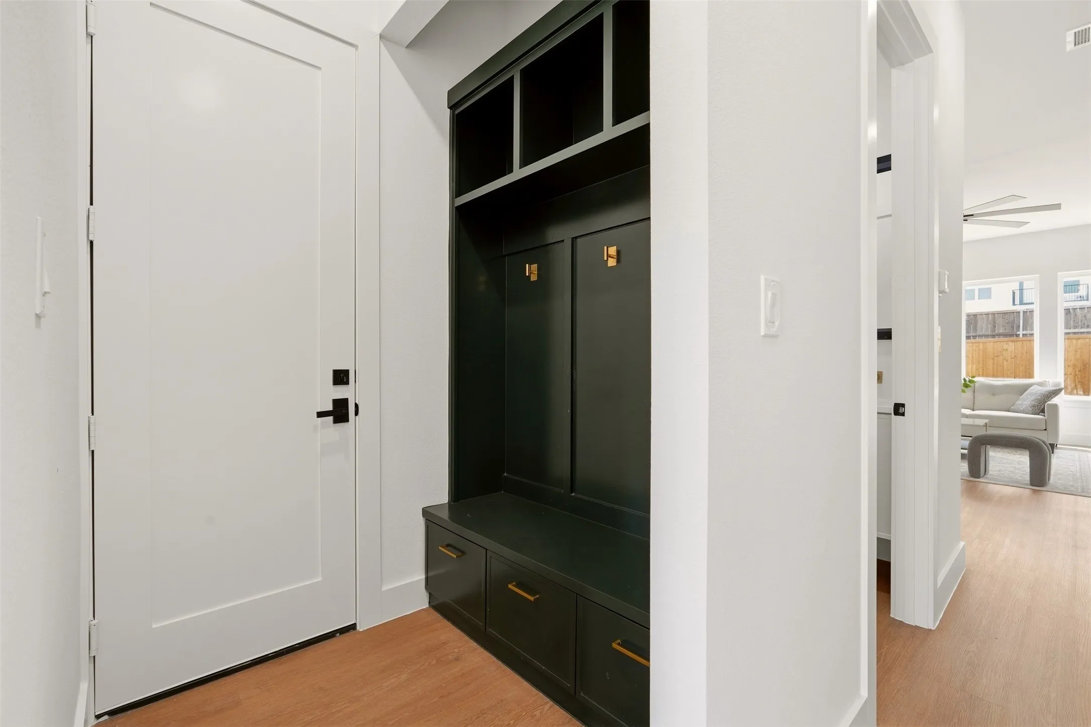 Built-in dark cabinetry with integrated bench seating, brass-finish hardware, and storage cubbies