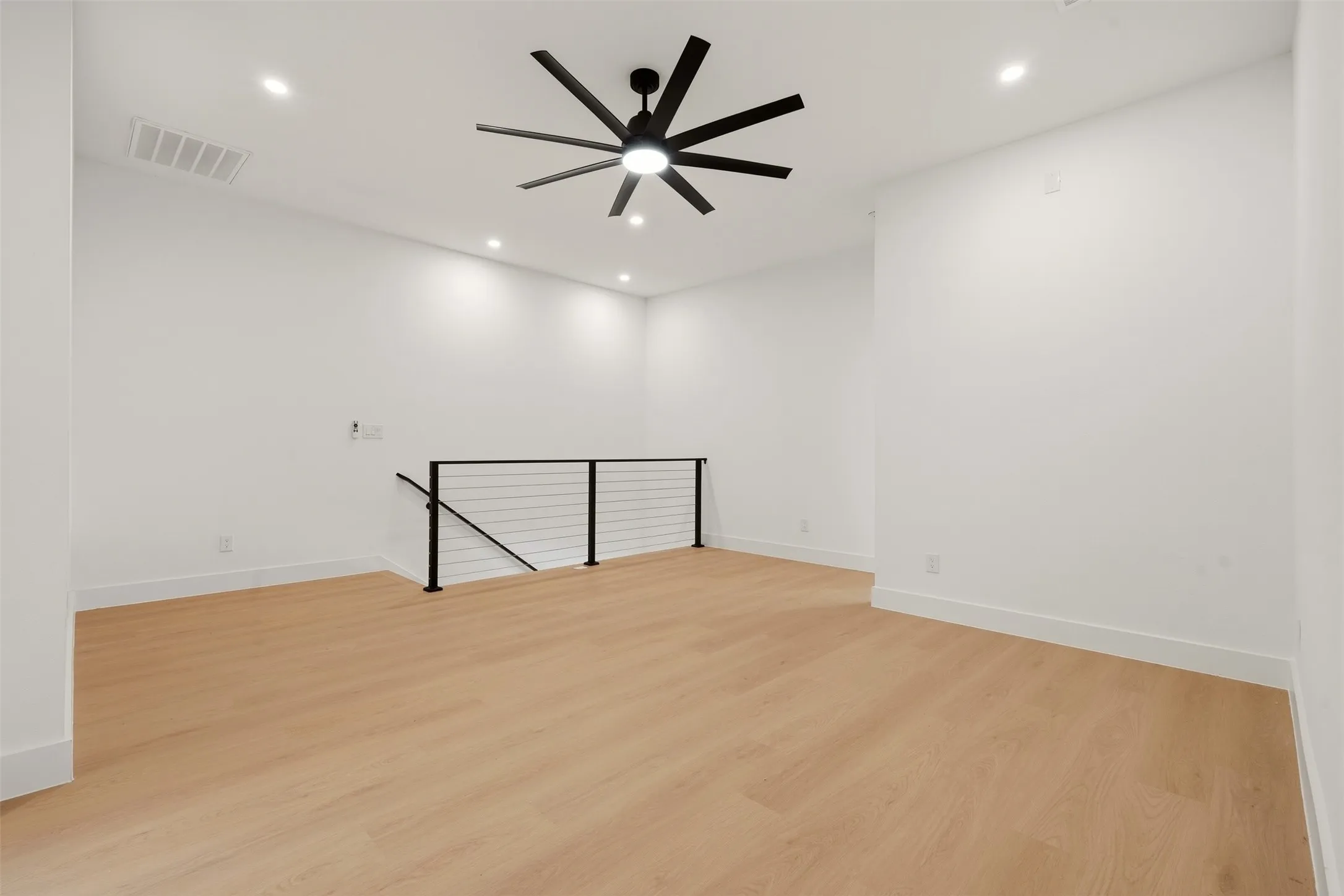 Recessed lighting, wood-finish flooring, contemporary ceiling fan, and modern cable railing