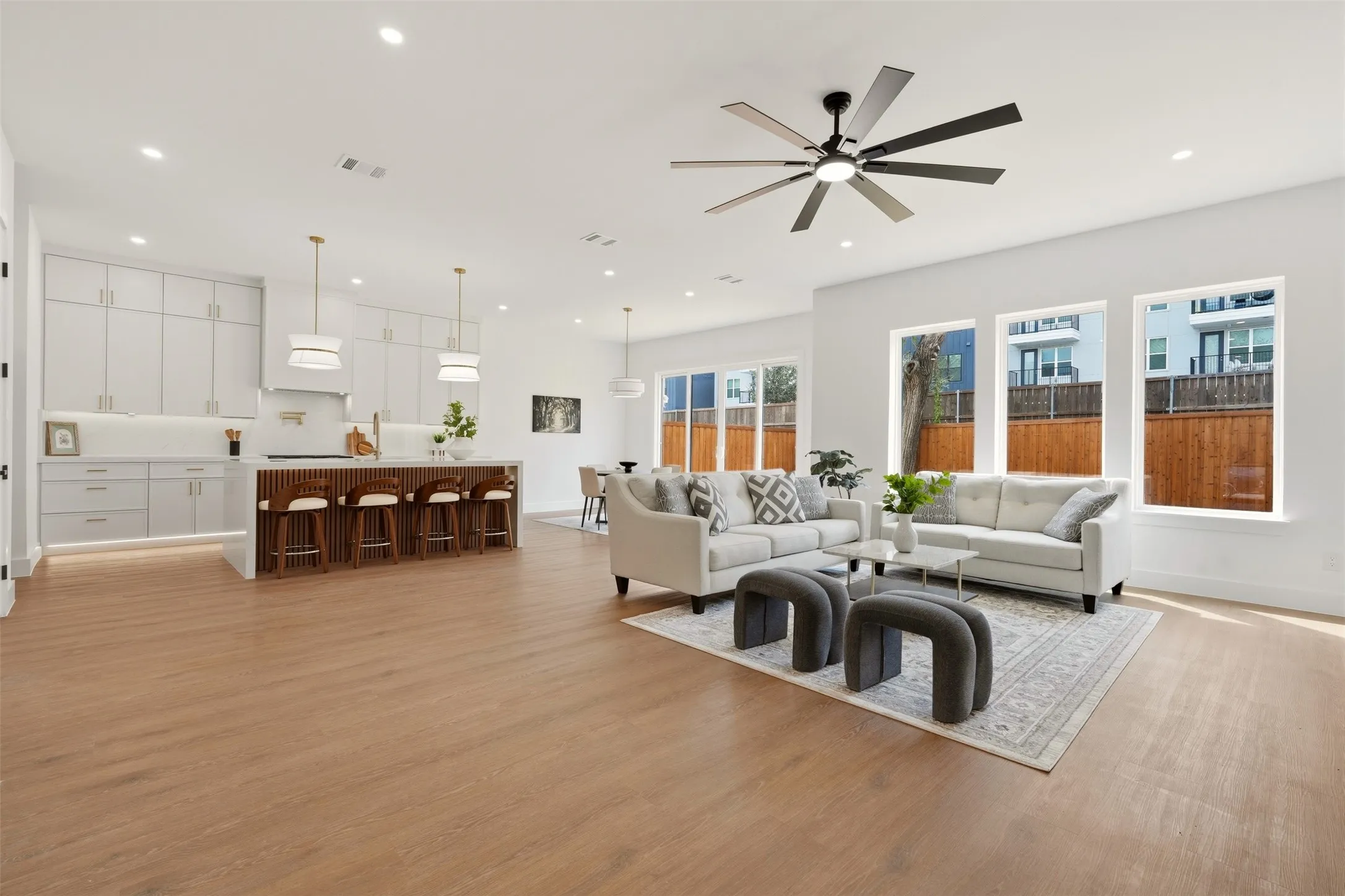Open-concept living space featuring wood-finish flooring, recessed lighting, and a contemporary ceiling fan