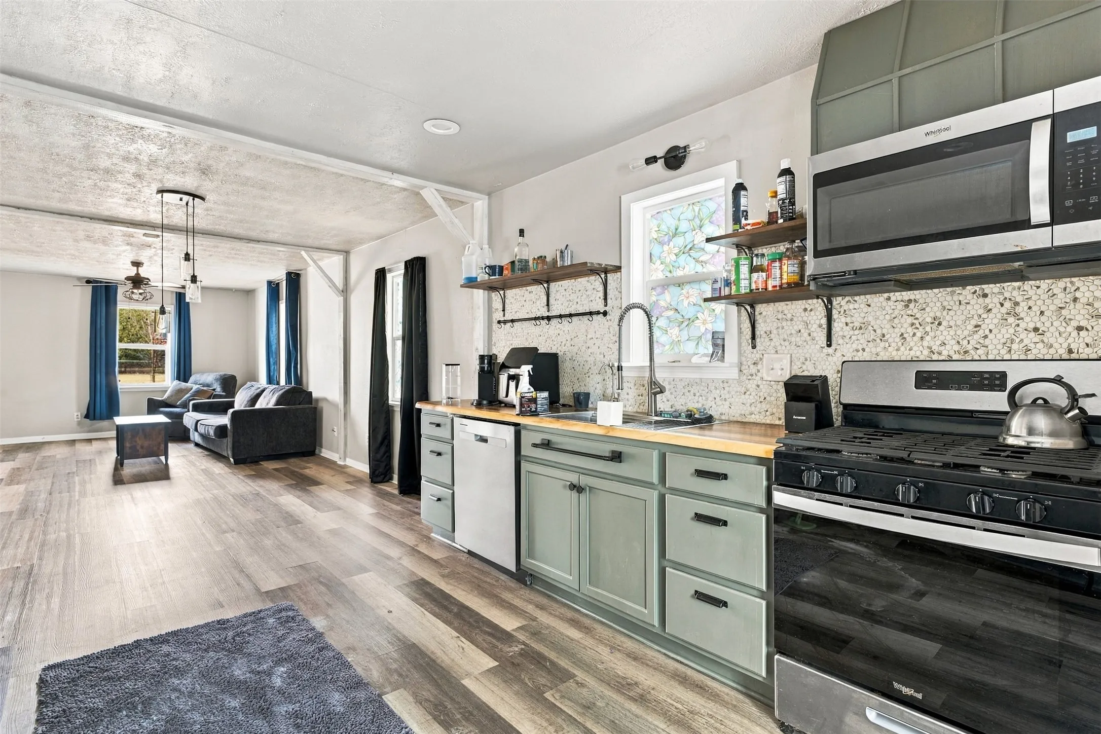 Open-concept living space featuring wood-finish flooring, recessed lighting, and a modern kitchen