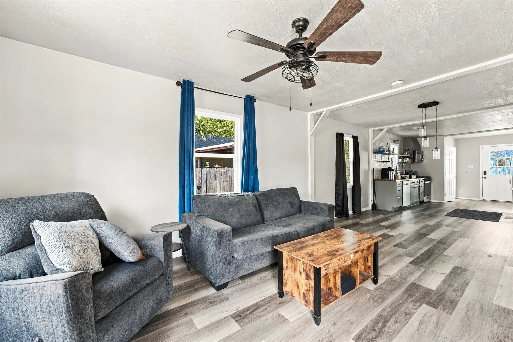 Expansive living space featuring wood-finish flooring and a ceiling fan