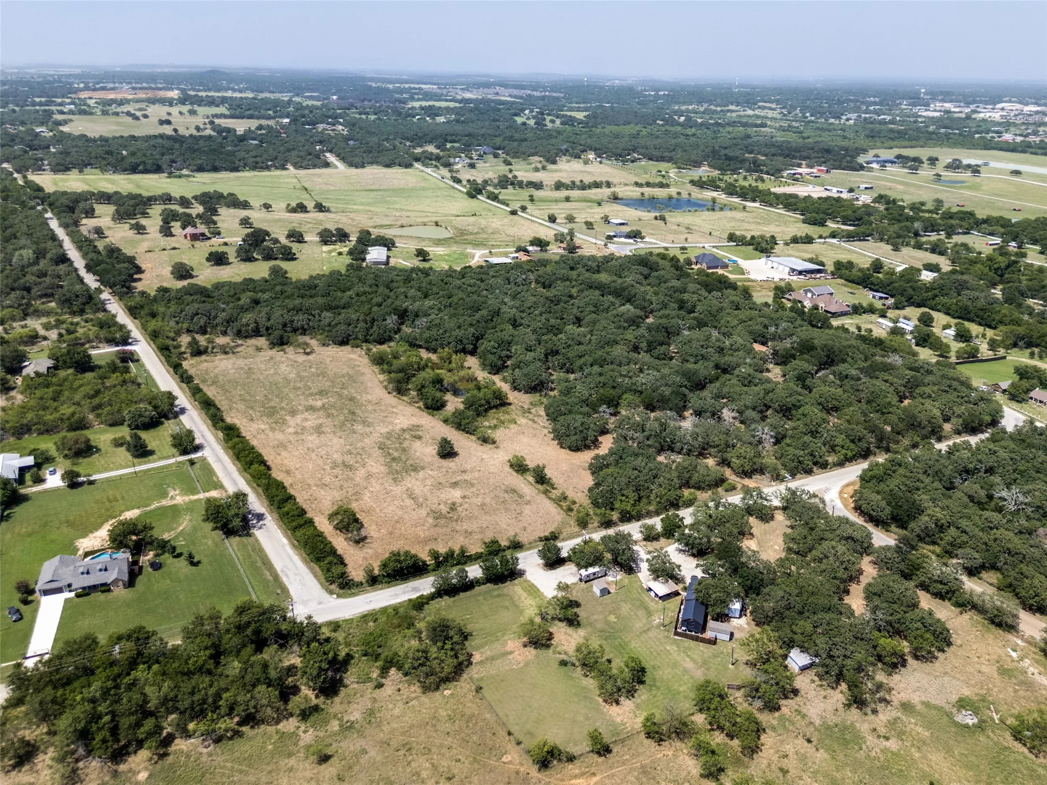 Expansive land parcel featuring a mix of open clearings and mature tree coverage