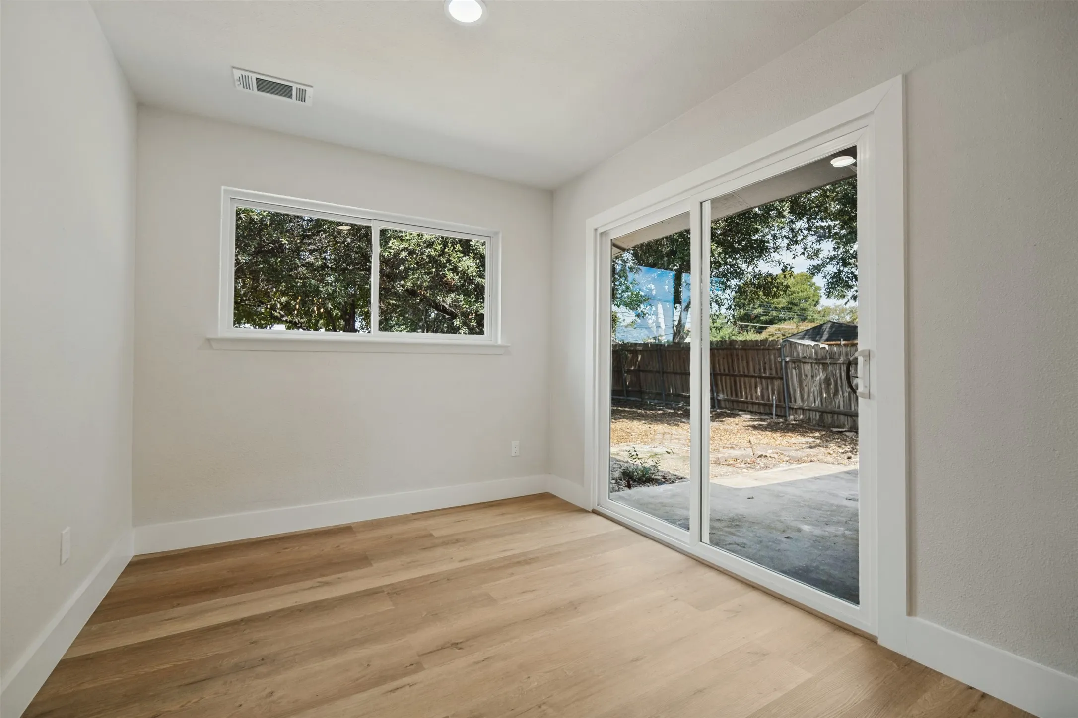 Wood-finish flooring, recessed lighting, and a window with white trim