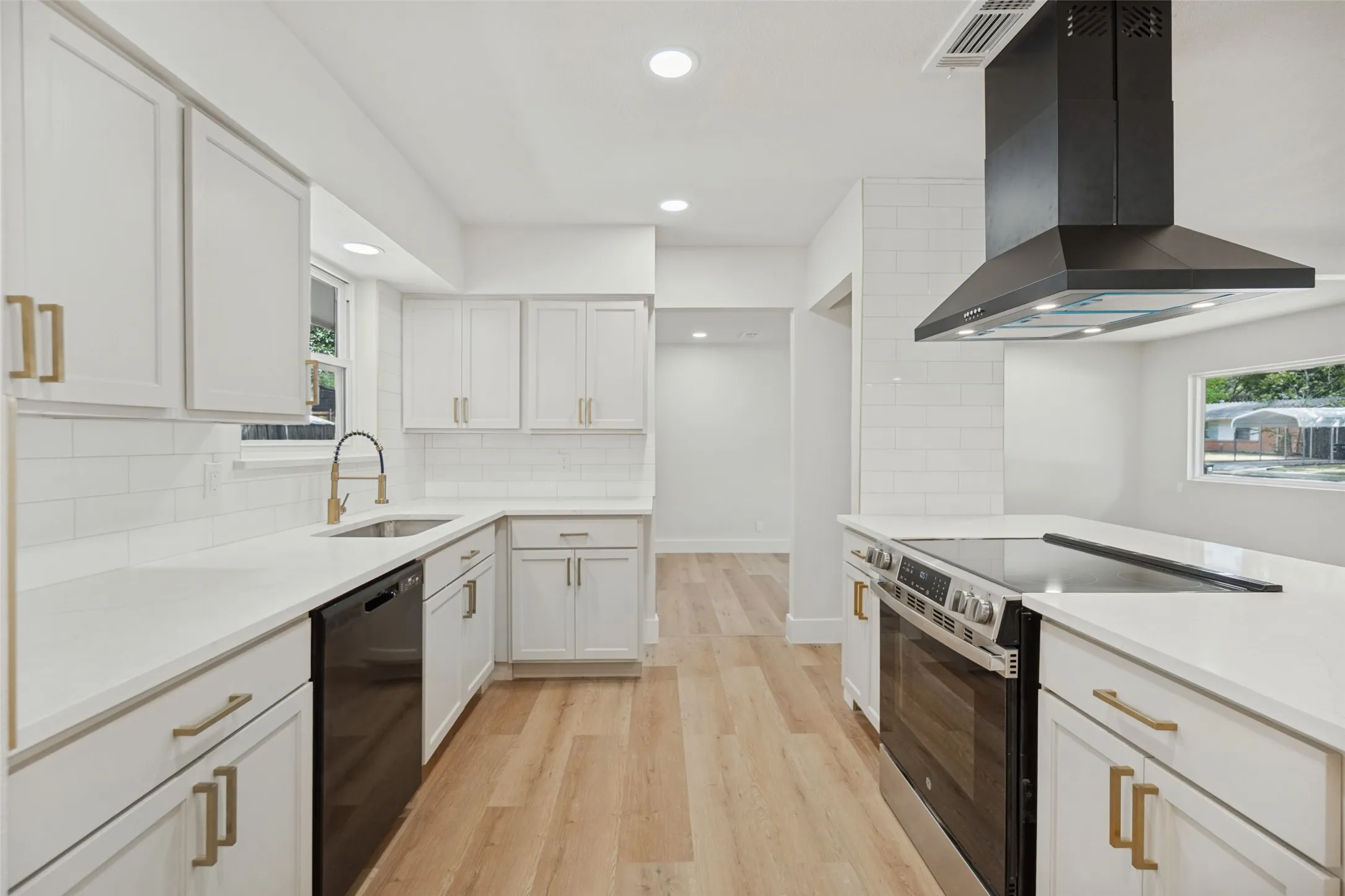Kitchen featuring white cabinetry, light countertops, wood-finish flooring, recessed lighting, and a black range hood