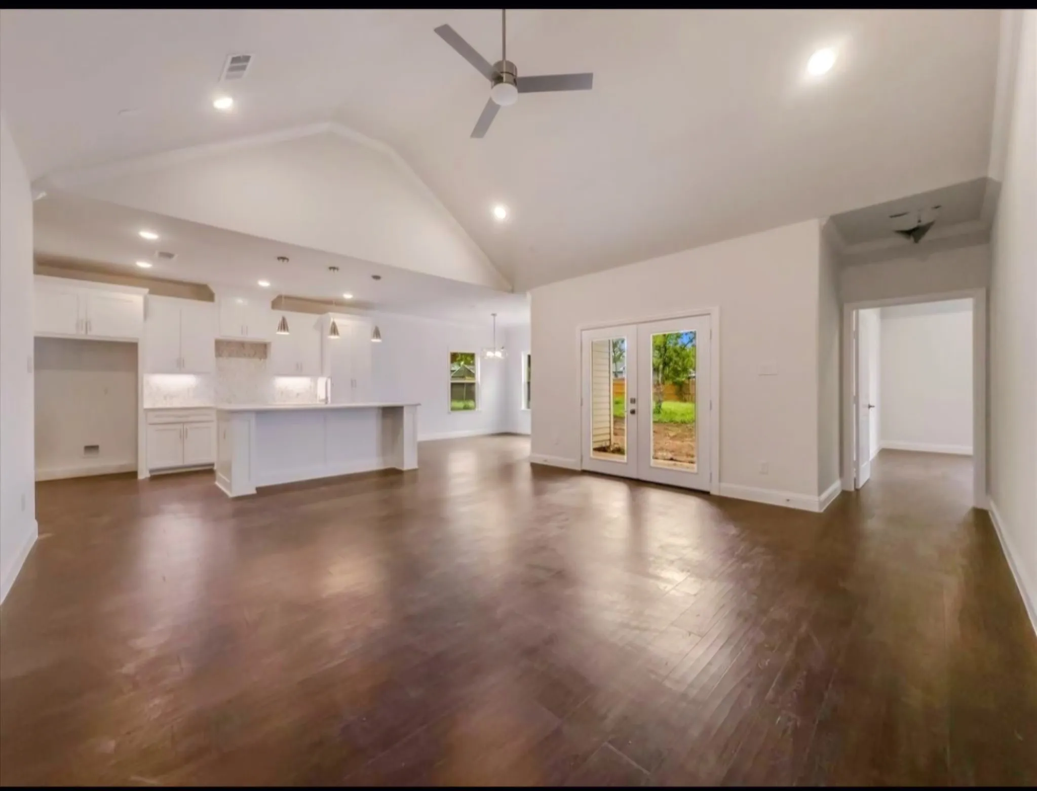 Unfurnished living room featuring recessed lighting, ceiling fan, high vaulted ceiling, and dark wood-type flooring