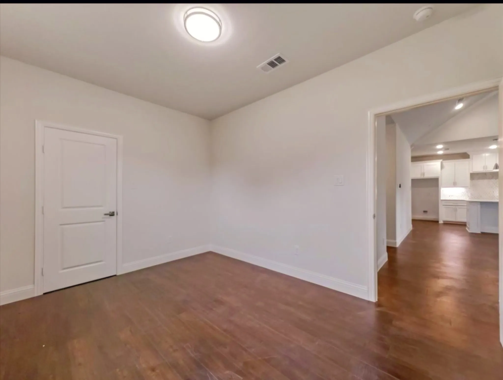 Empty room featuring dark wood-type flooring and lofted ceiling