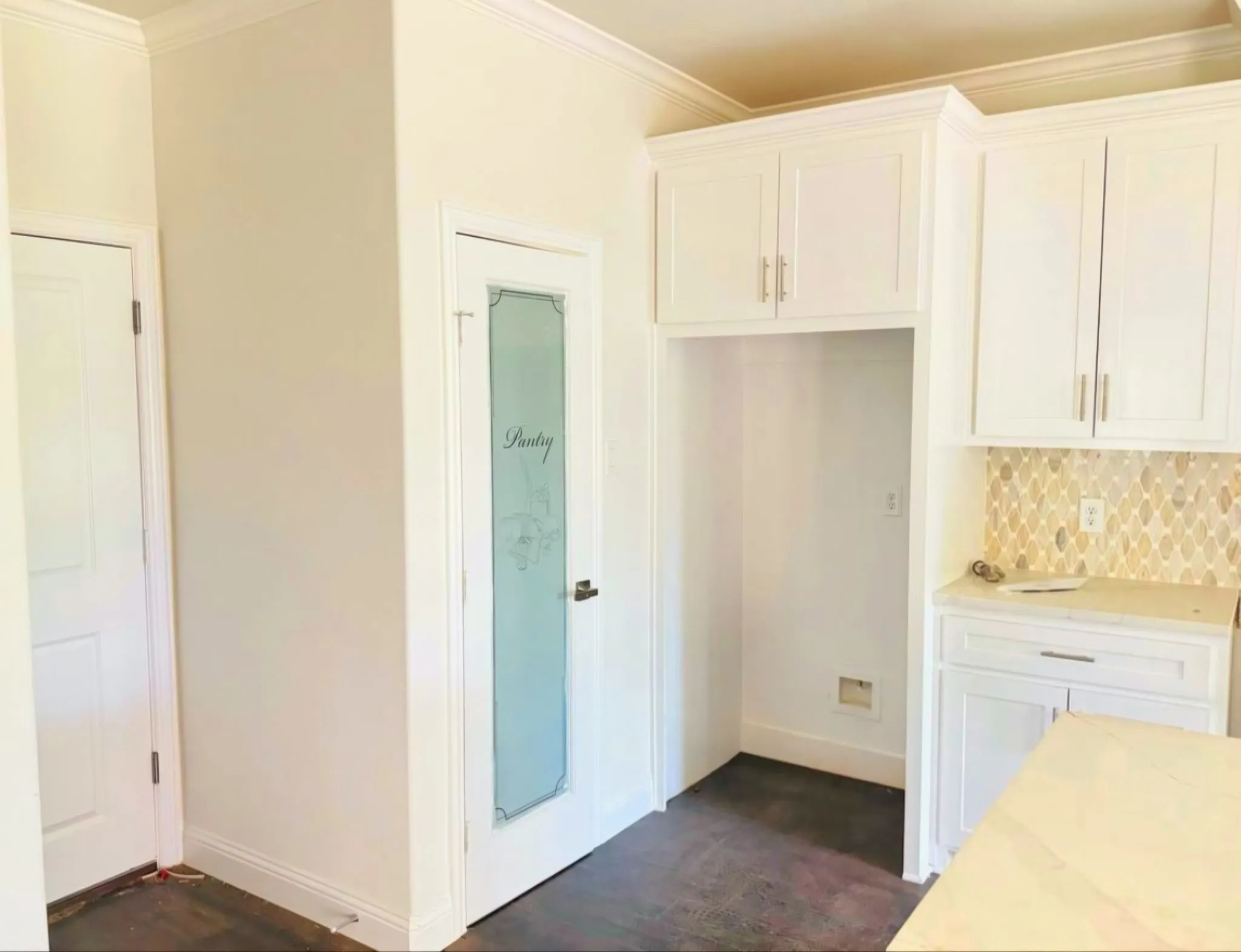 Kitchen with white cabinets, ornamental molding, light stone counters, tasteful backsplash, and dark wood finished floors