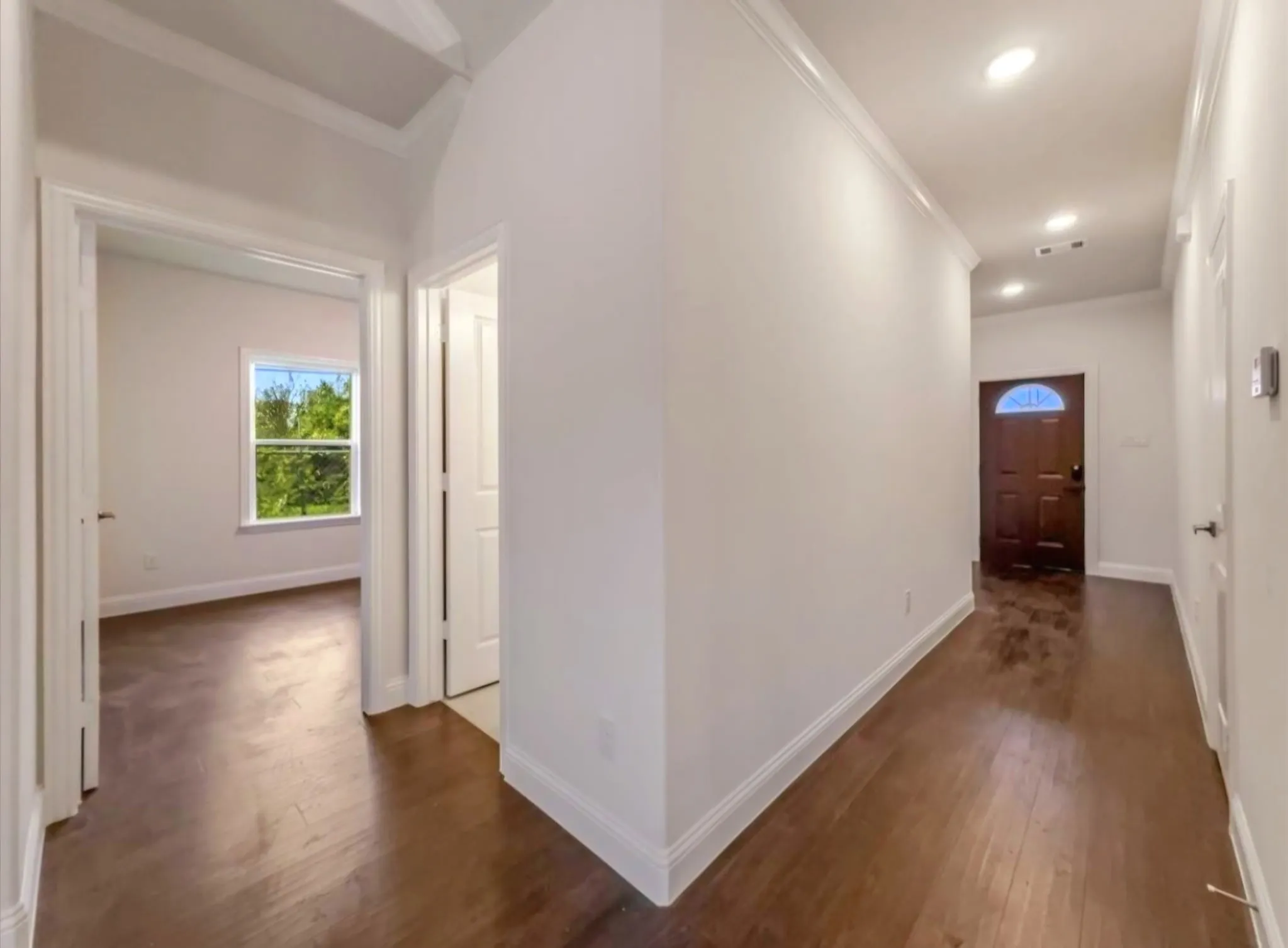 Hall featuring crown molding and dark wood-style flooring