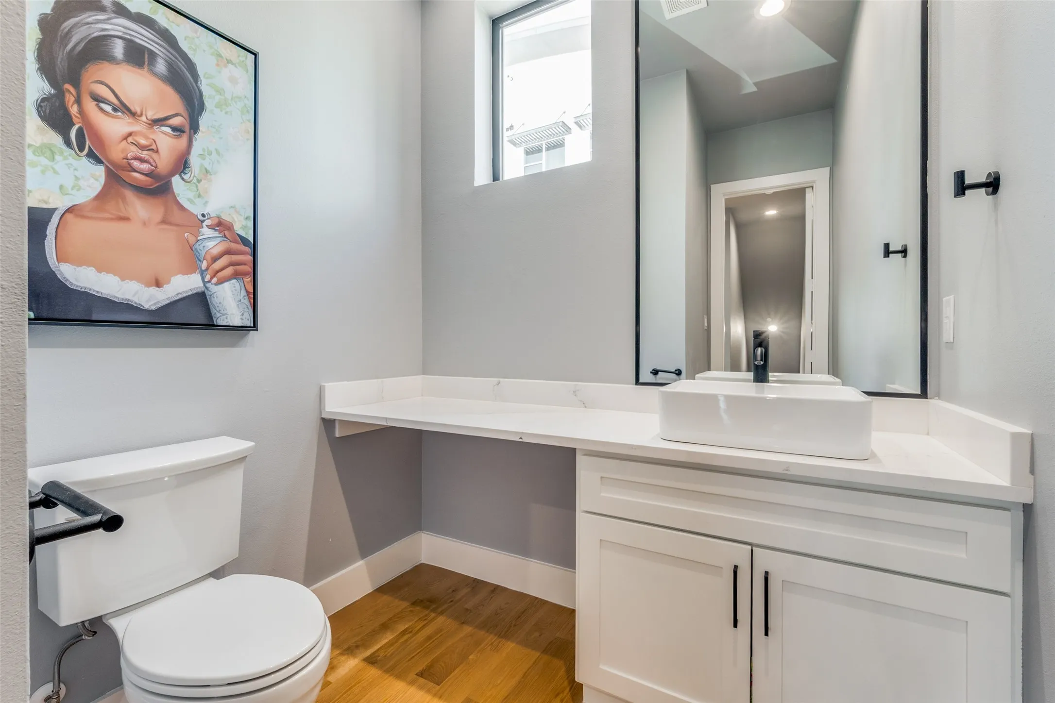 White rectangular vessel sink with a matte black faucet, set on a white countertop with integrated cabinetry