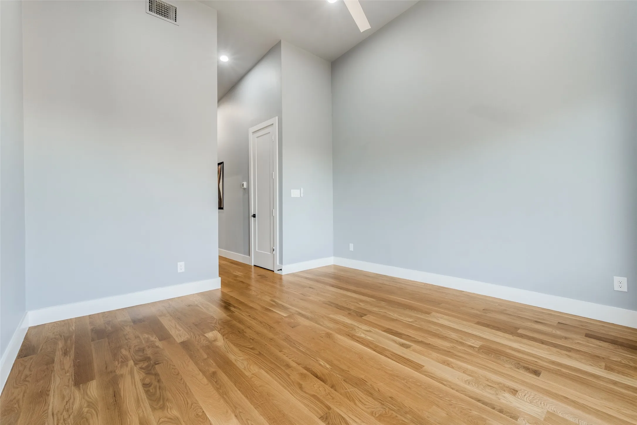 Hardwood flooring, painted walls, vaulted ceiling, recessed lighting, and a ceiling fan