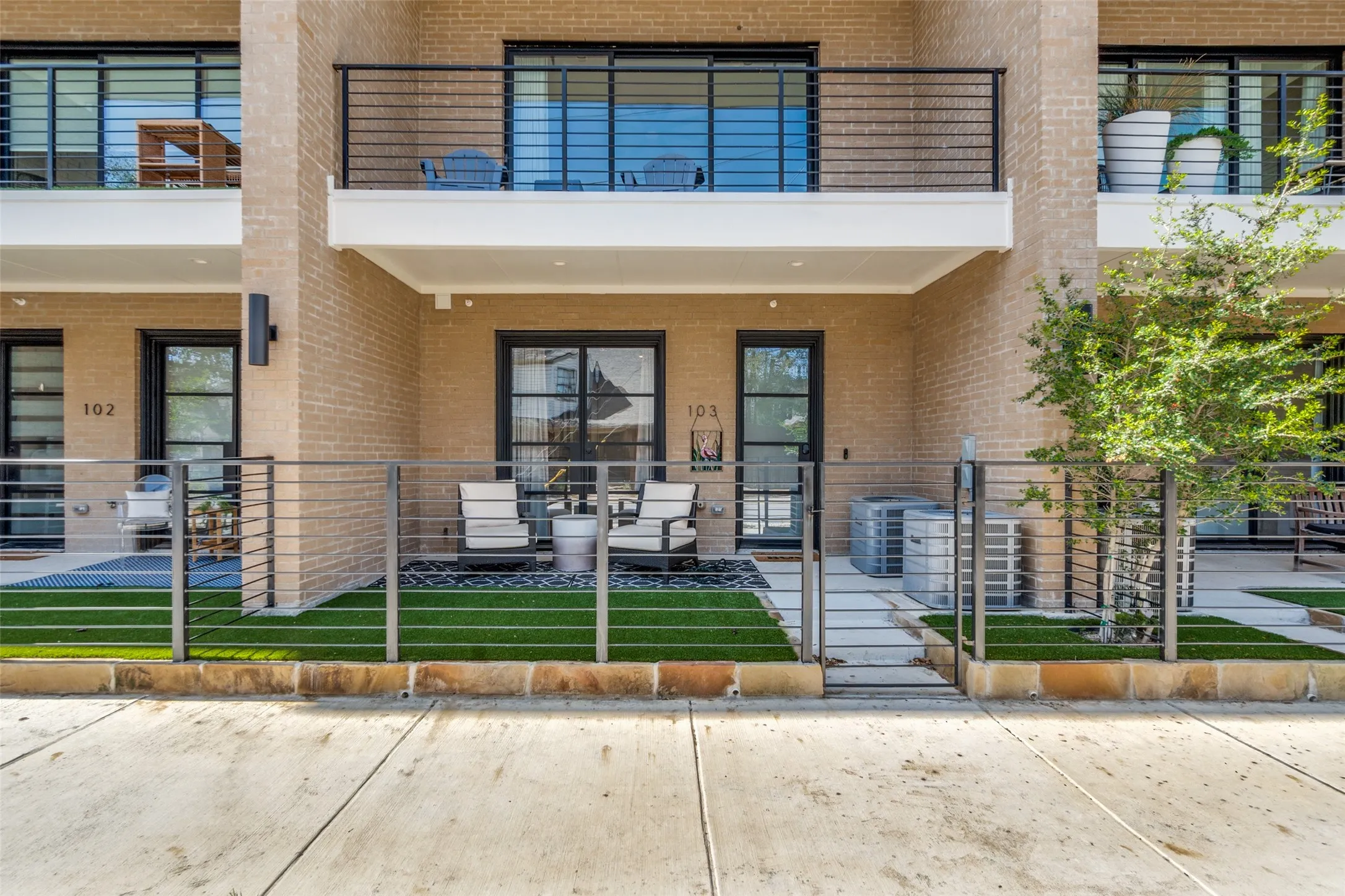 Brick facade with private patio featuring artificial turf