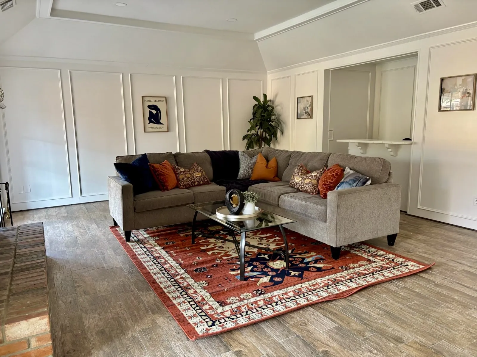 Vaulted ceiling, wood-finish flooring, wainscoting, brick hearth, and pass-through opening