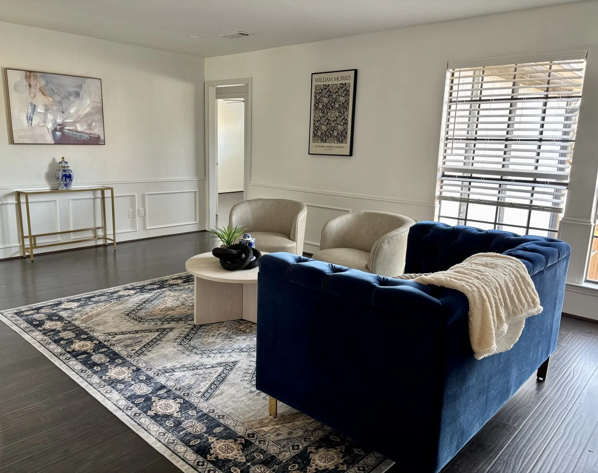 Dark wood-finish flooring with white baseboards and wainscoting