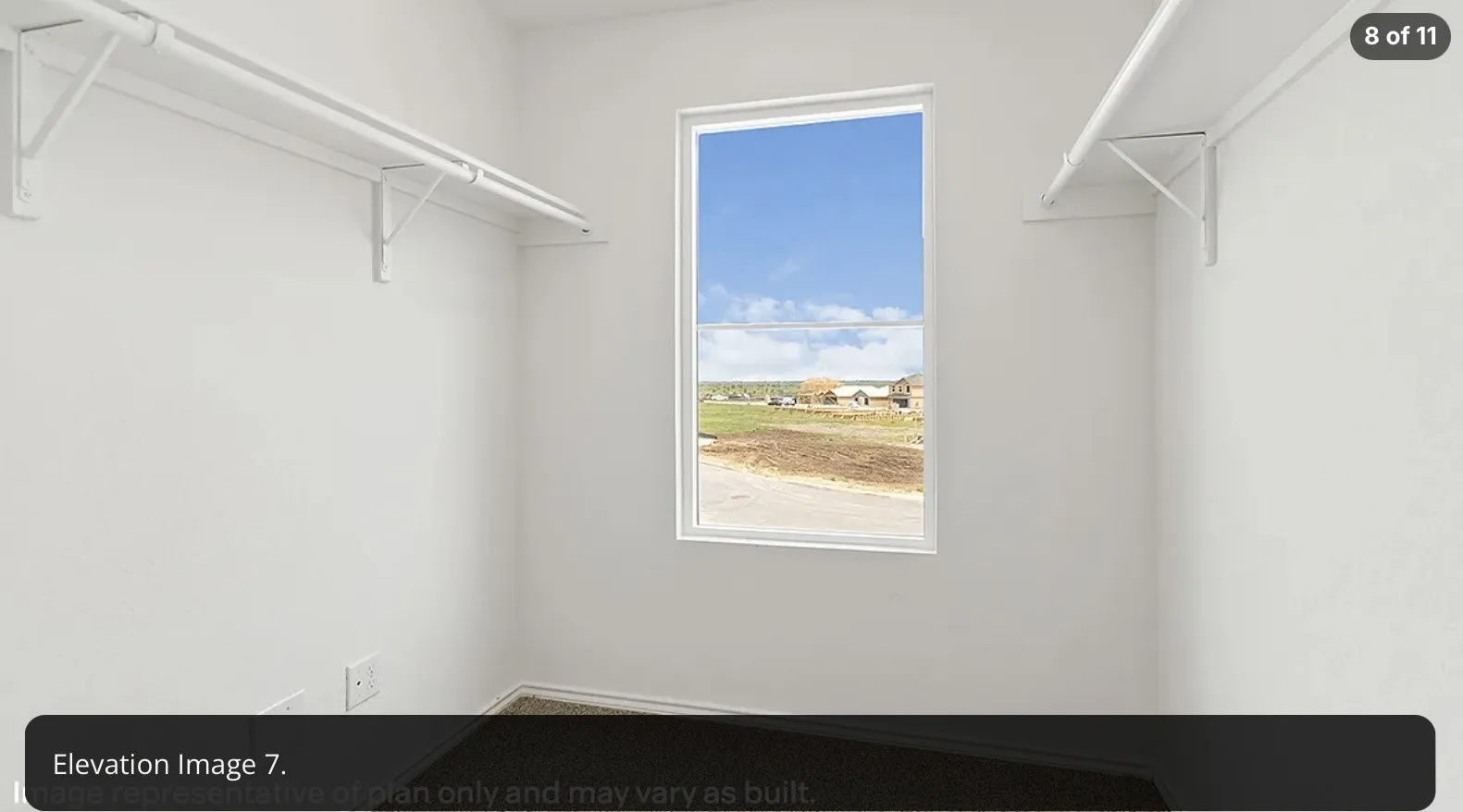 Windowed closet with white shelving and hanging rods