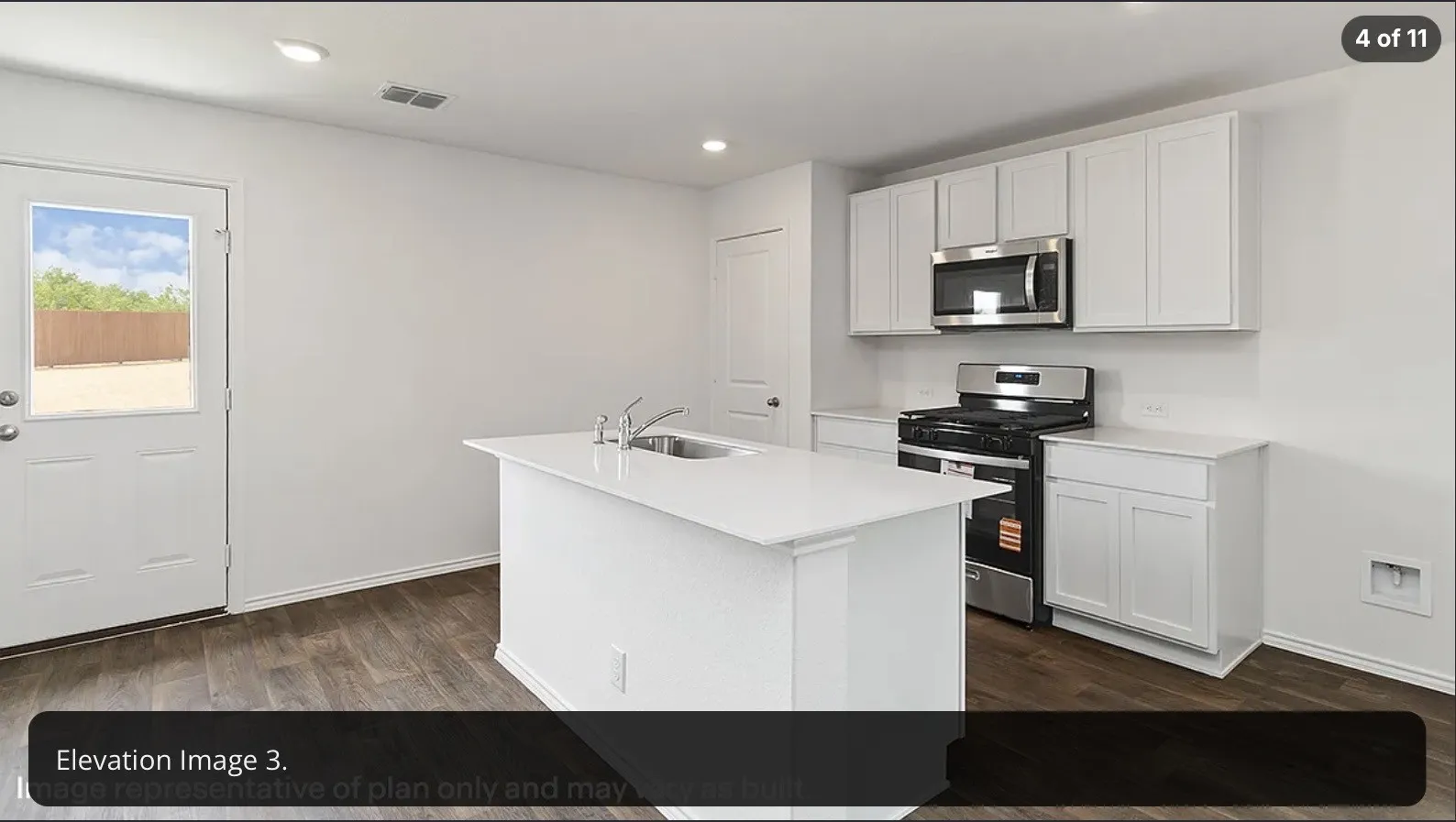 Kitchen featuring a center island with an integrated sink, stainless steel appliances, white cabinetry, recessed lighting, and wood-finish flooring