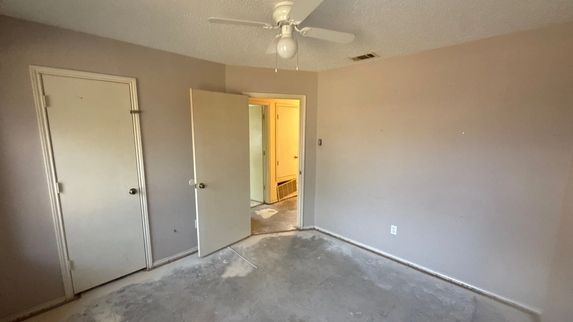 Ceiling fan, neutral wall color, and interior door with doorknob