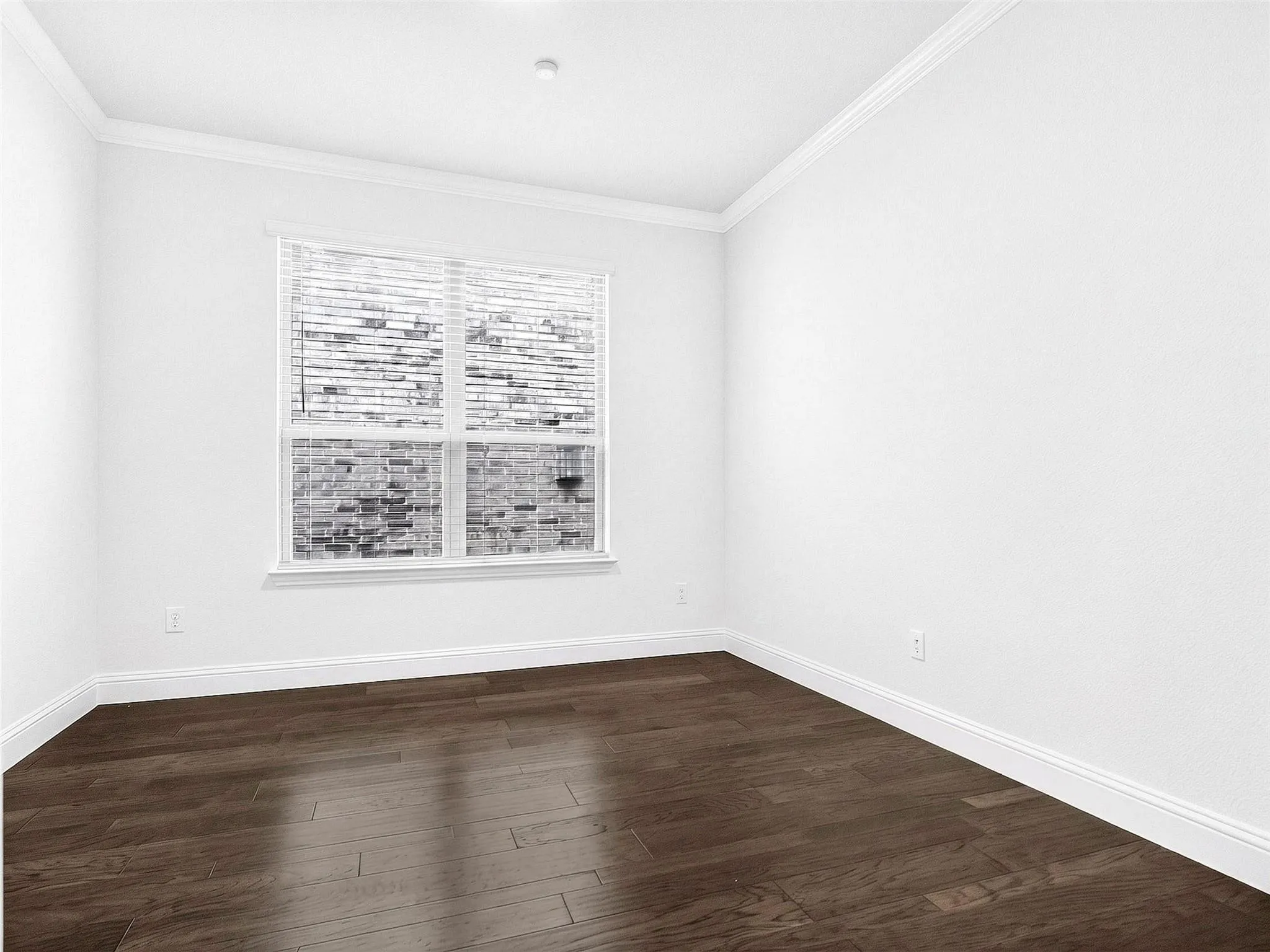 Hardwood-finish flooring, white painted walls, crisp white crown molding, and a double-paned window with horizontal blinds