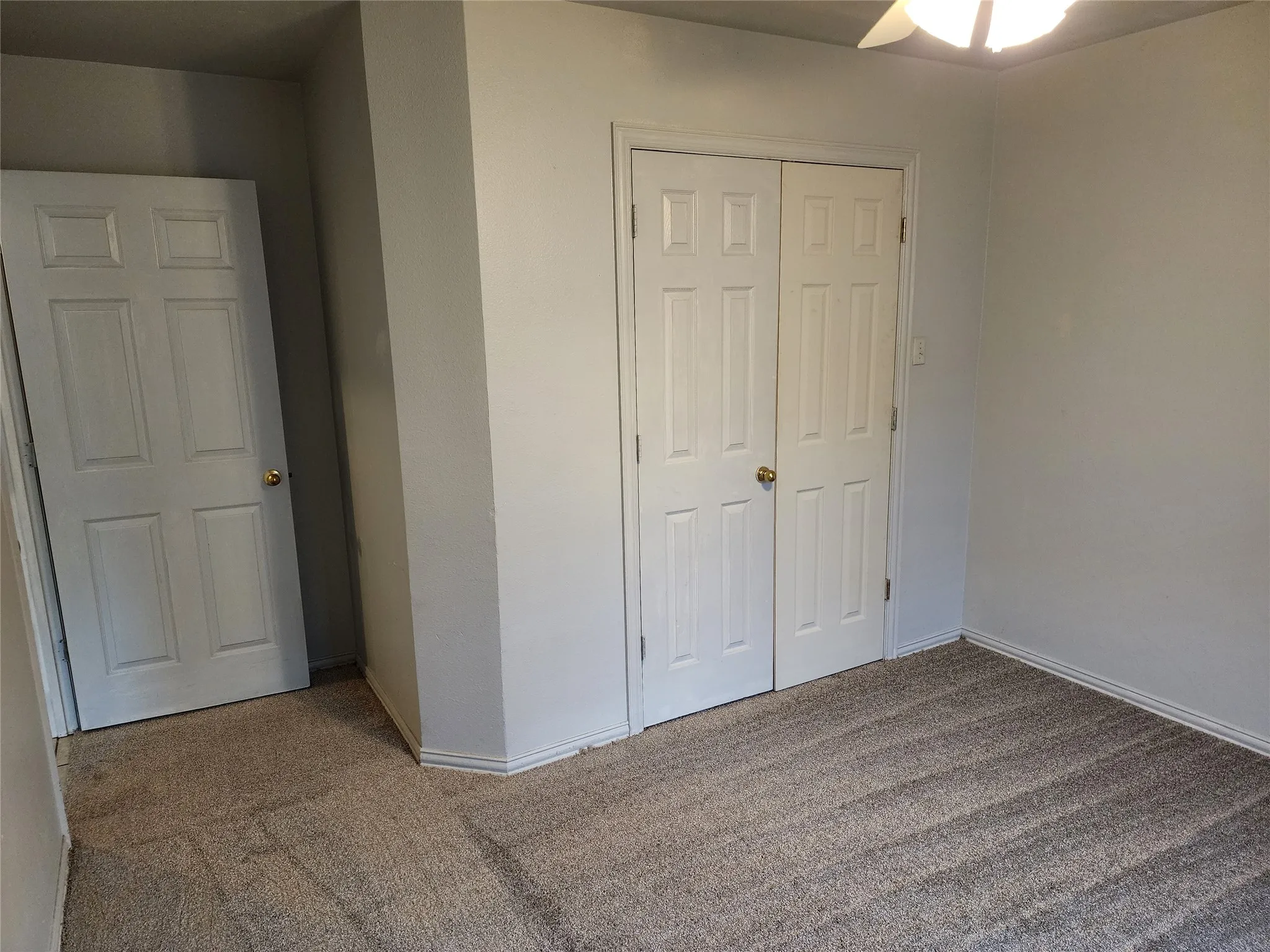 Wall-to-wall carpet flooring, neutral paint palette, paneled interior doors, and built-in closet with bifold doors
