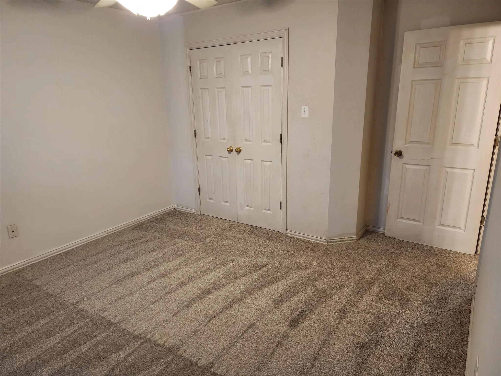 Neutral carpeting with a subtle pattern and white panel doors