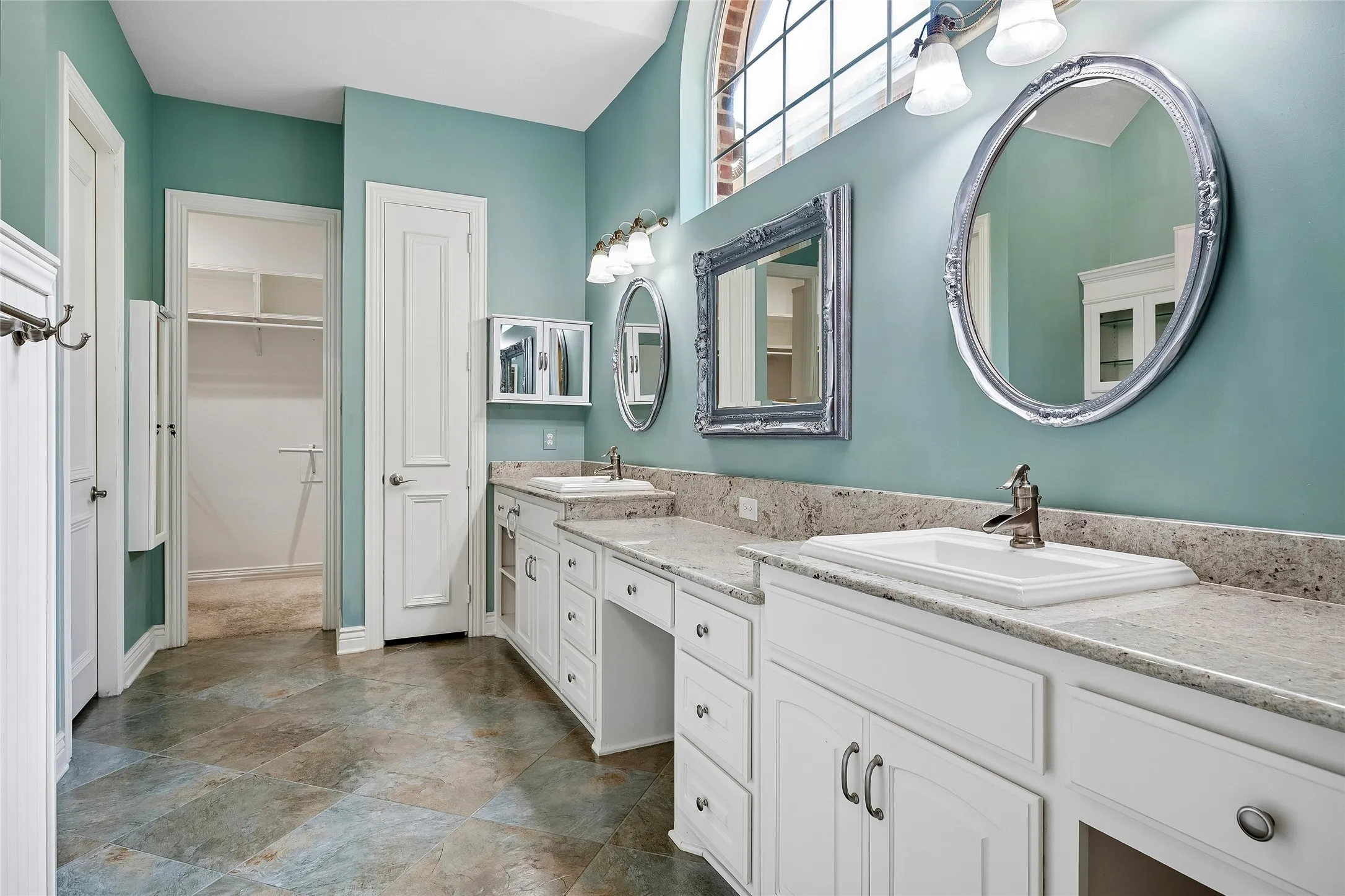 Updated primary bathroom with custom tile, double sinks, built in vanity, linen closet, walk in closet.