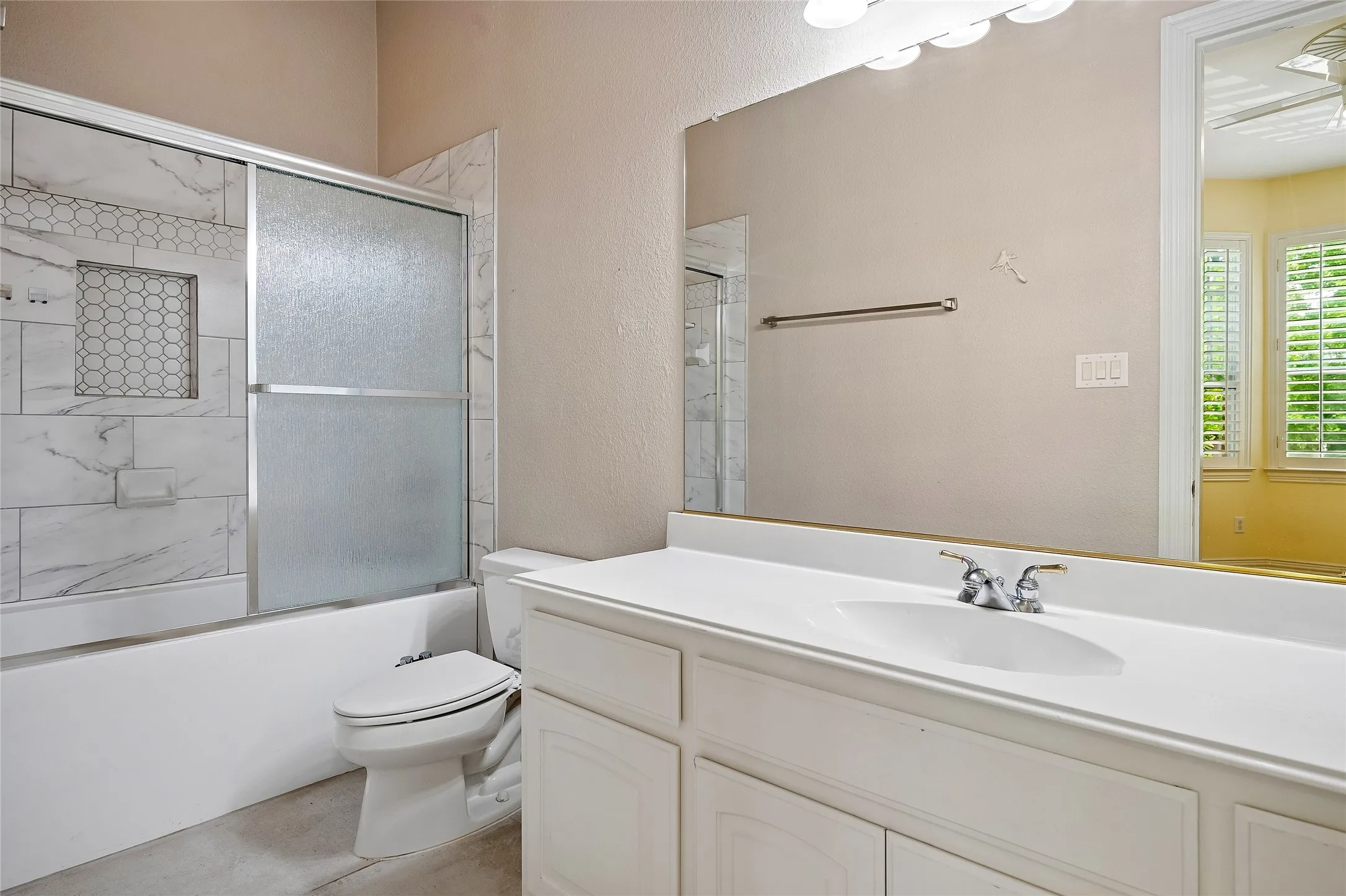 Updated bath with enclosed, sliding glass door, custom tile.