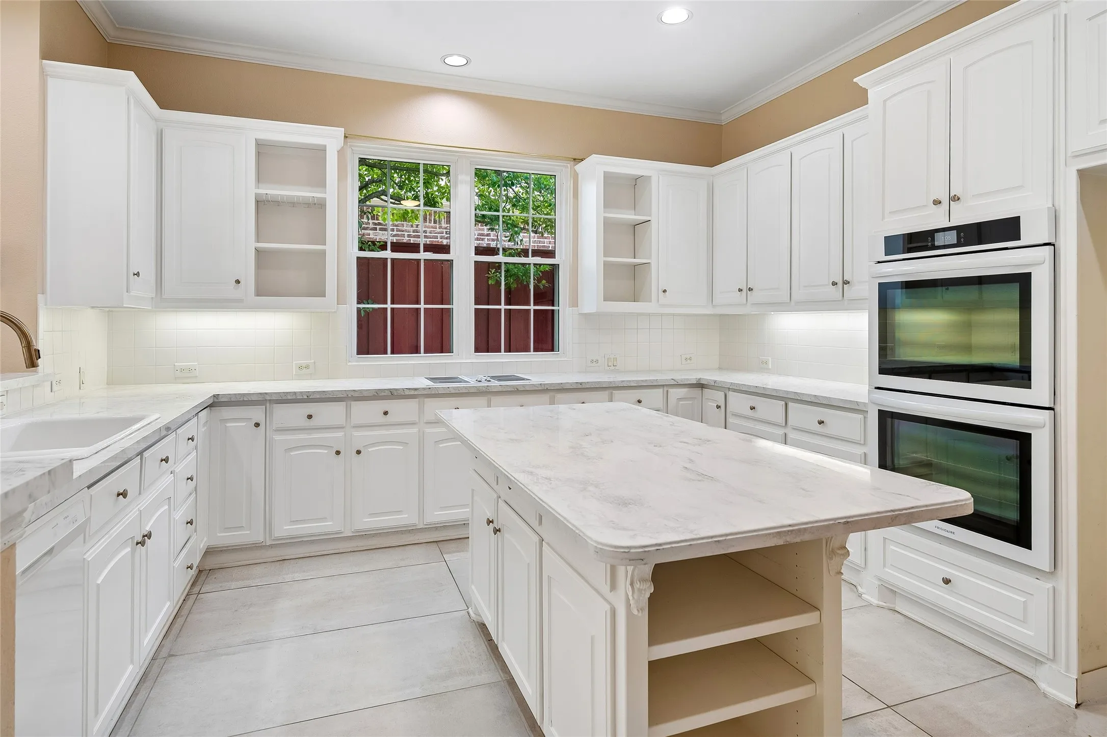 Beautiful all white kitchen with large double ovens, island.