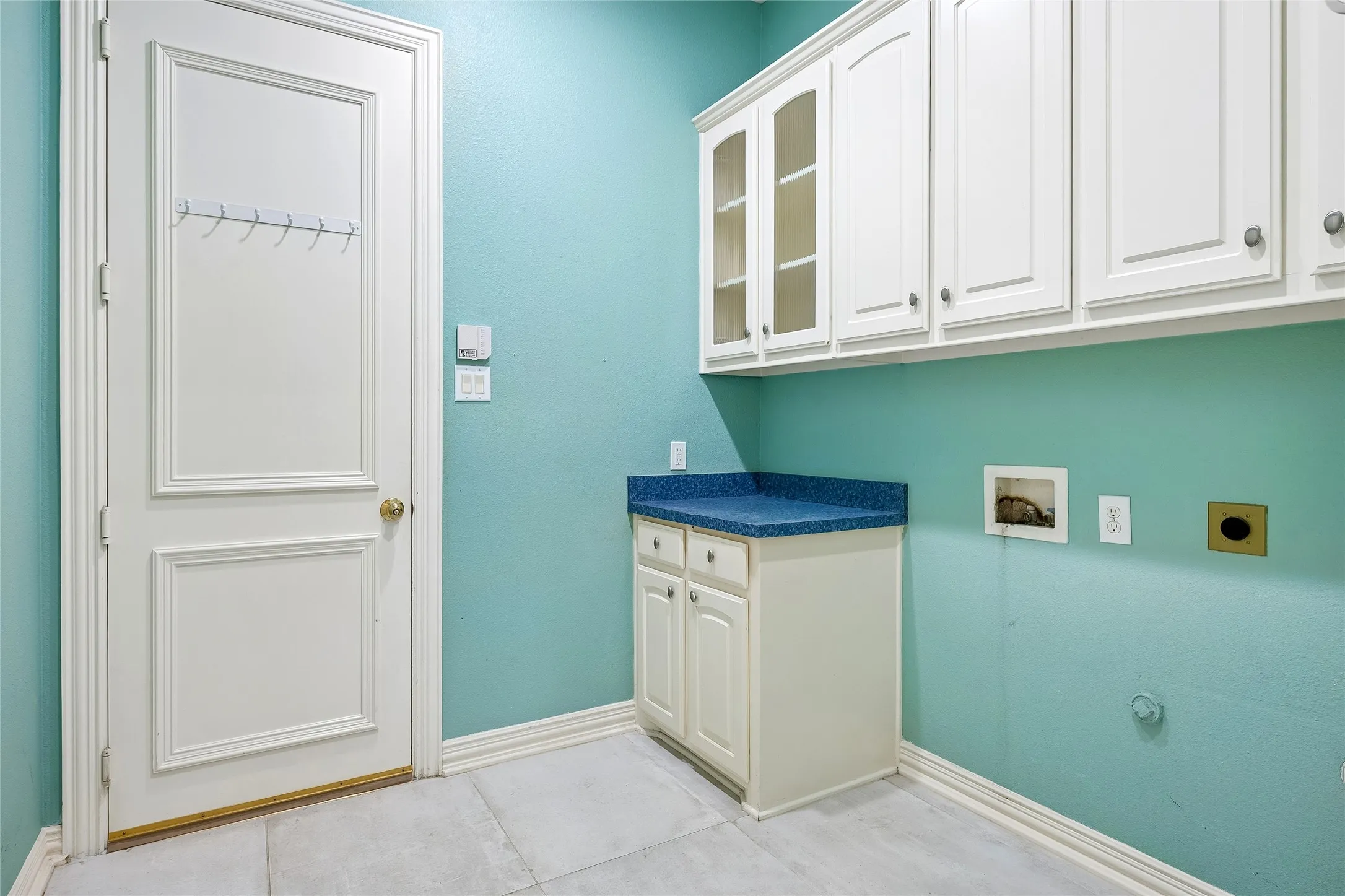 Large laundry room with an abundance of cupboards.