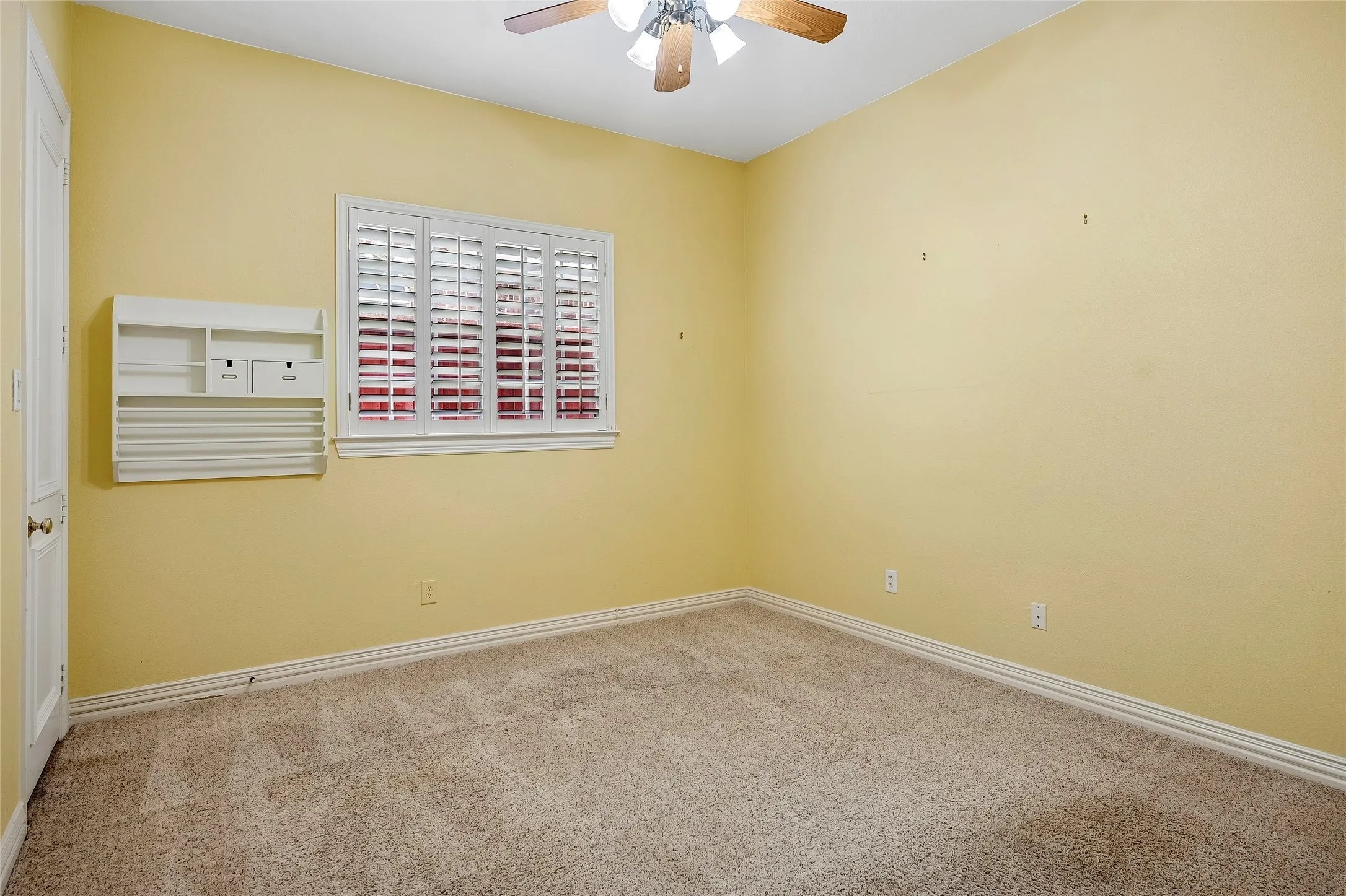 Window with shutters, ceiling fan, wall built-in.