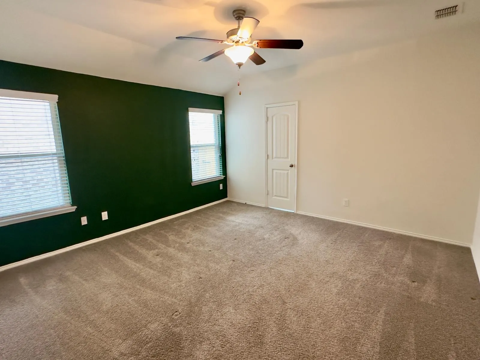 Carpeted spare room with lofted ceiling and ceiling fan