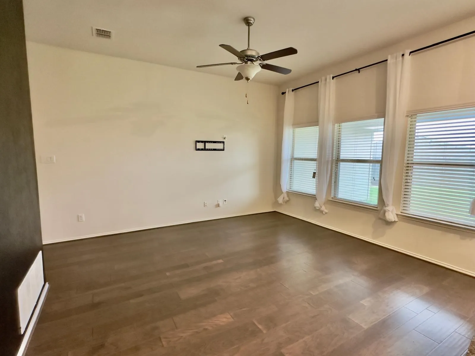 Spare room featuring dark hardwood / wood-style flooring and ceiling fan