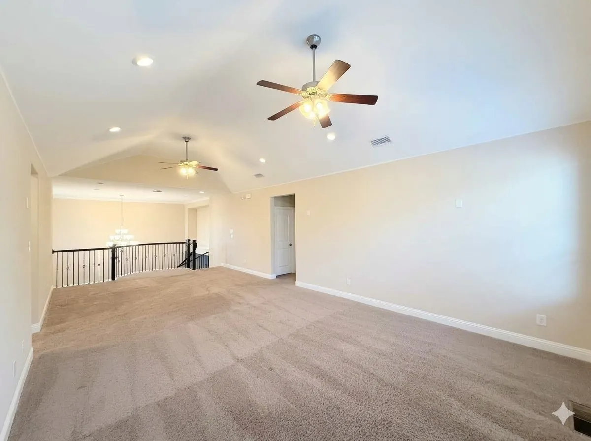 Vaulted ceiling with recessed lighting, two ceiling fans, carpeted flooring, and a black wrought iron railing