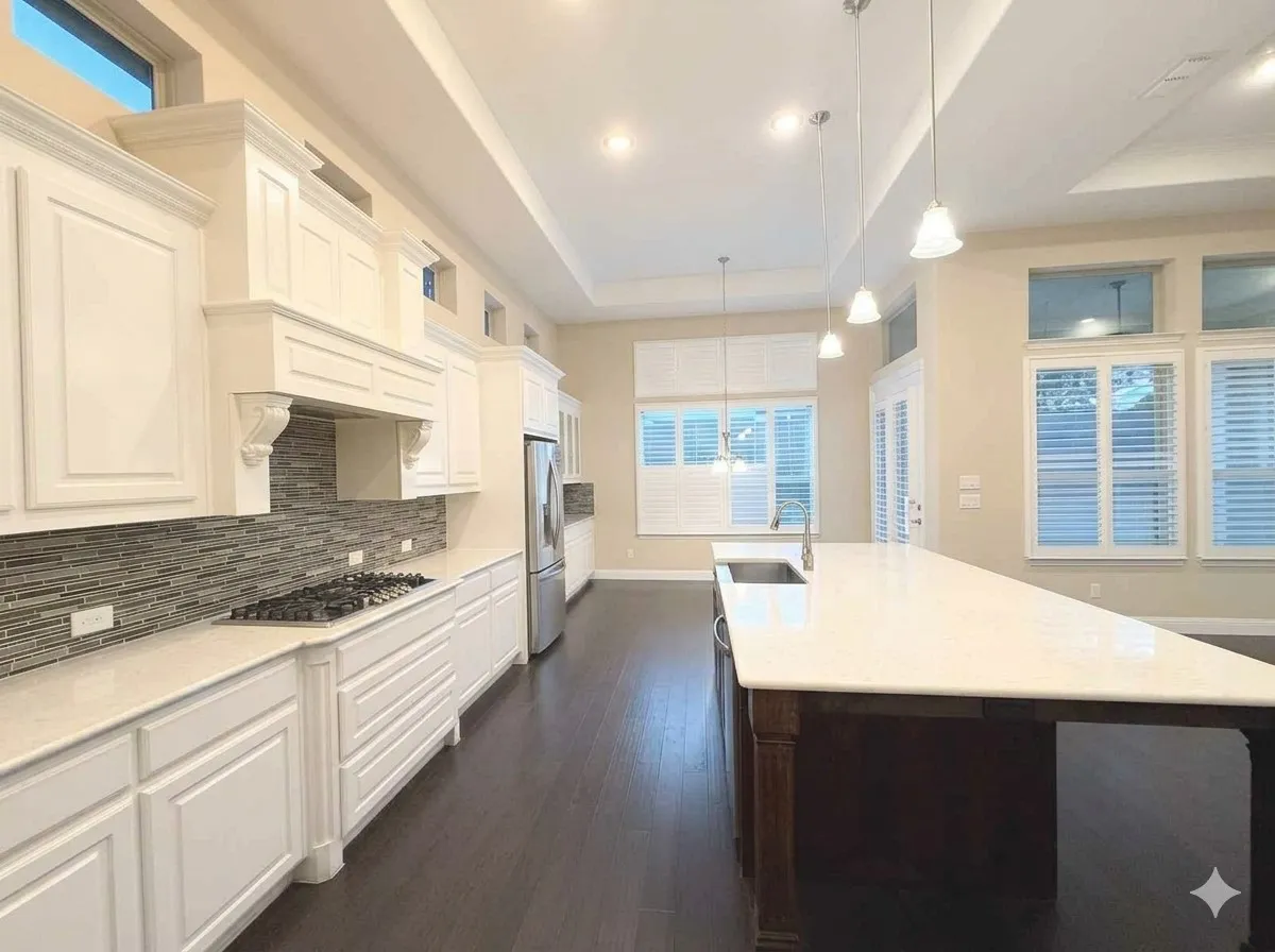 Spacious kitchen featuring white cabinetry, a large island with an undermount sink, a gas cooktop, stainless steel appliances, and dark wood-finish flooring