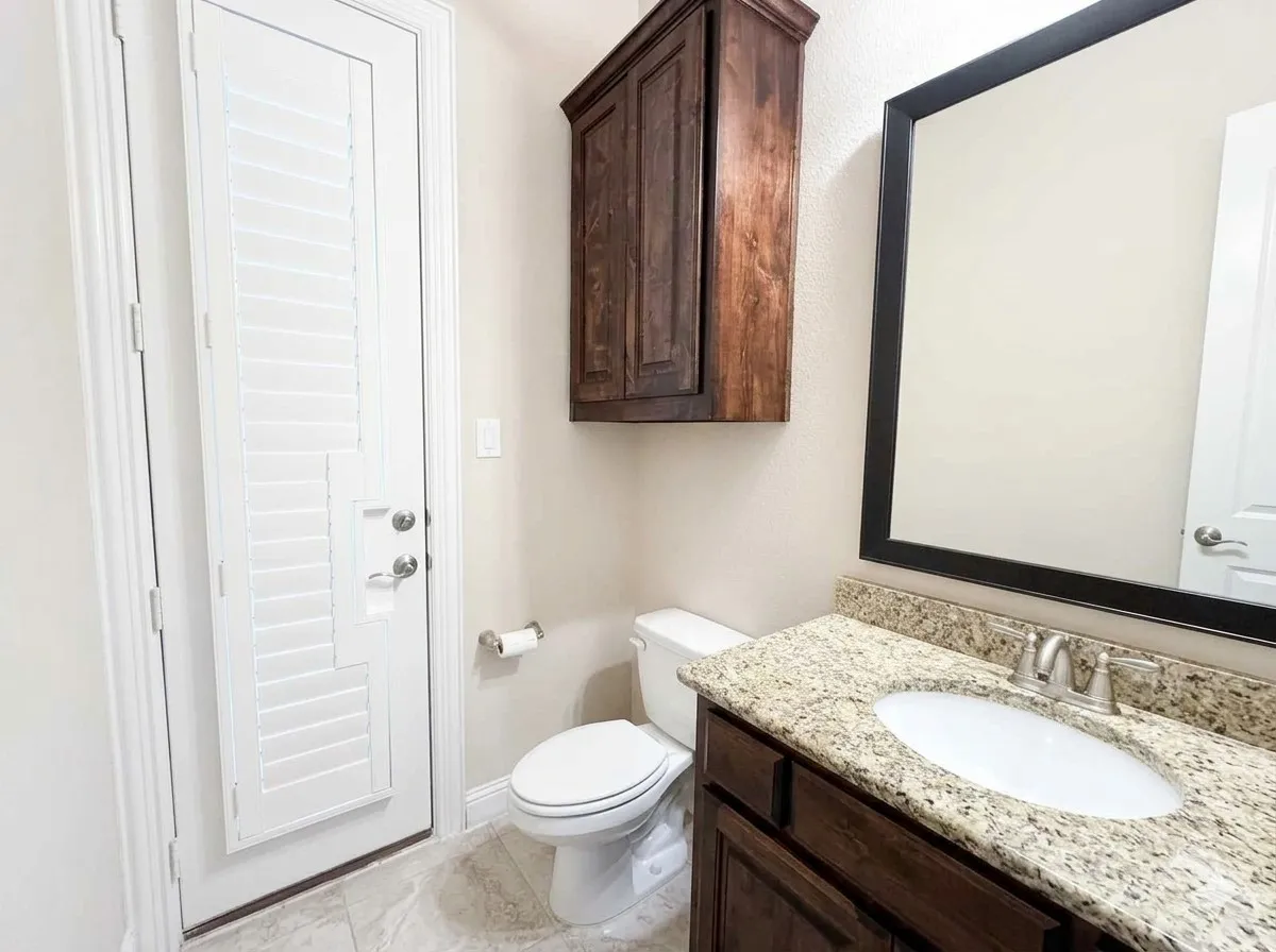 Vanity with a granite countertop, undermount sink, and brushed nickel faucet