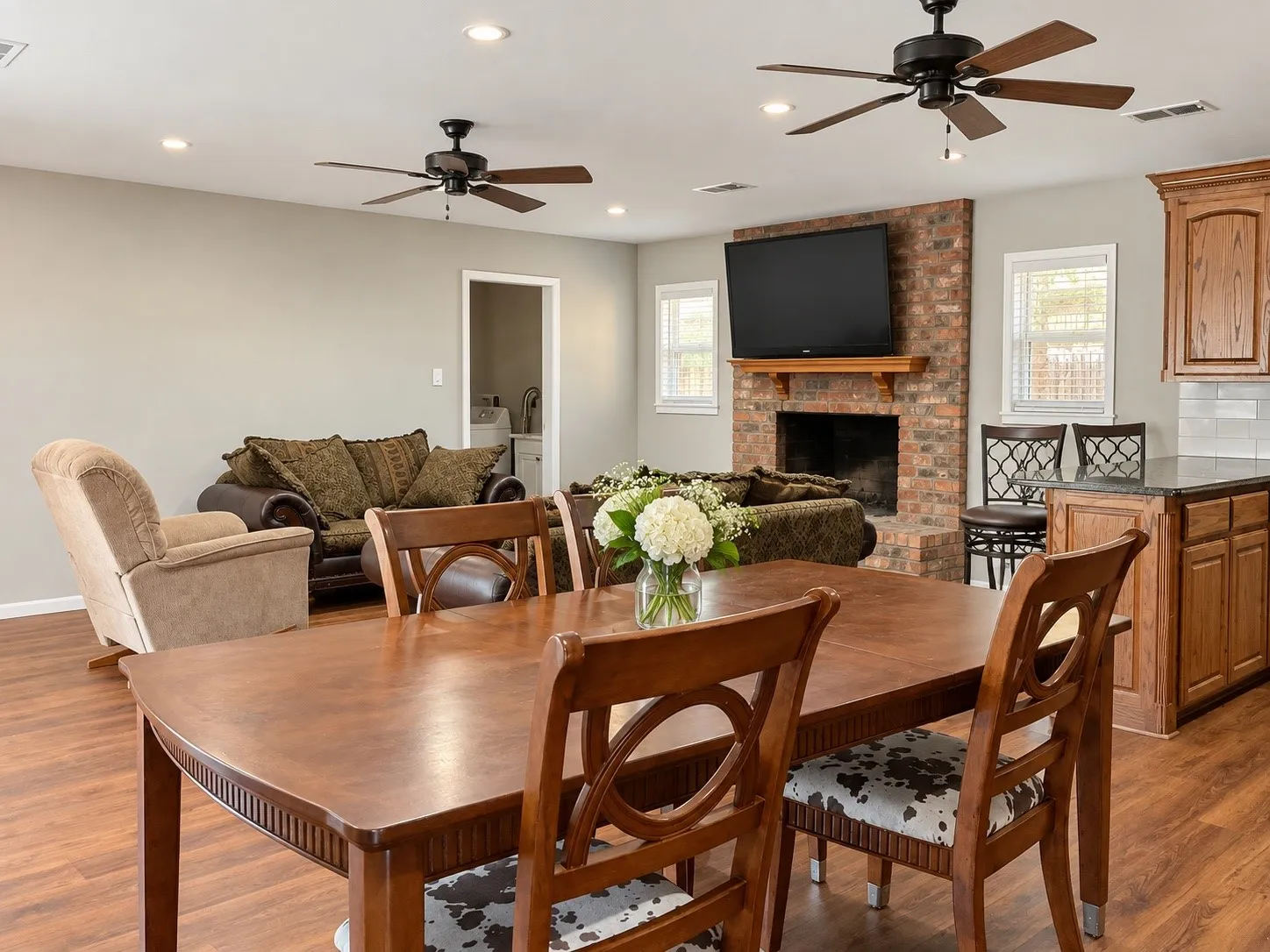 Open-concept living area featuring wood-finish flooring, recessed lighting, and ceiling fans