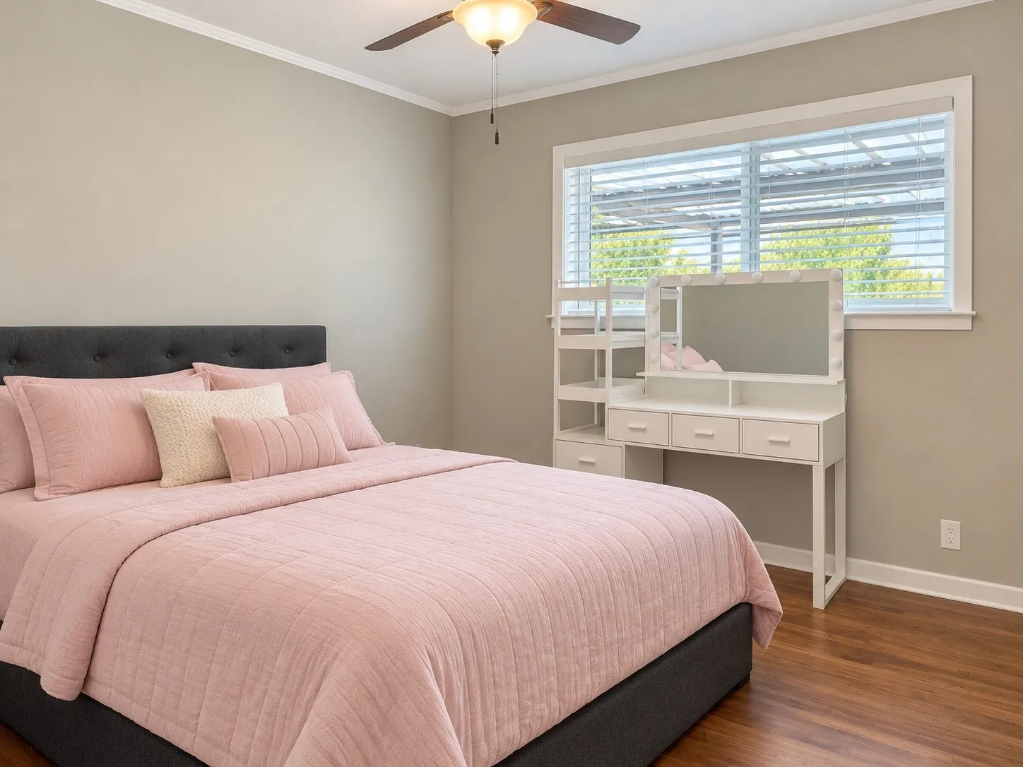 Wood-finish flooring with crown molding and a ceiling fan