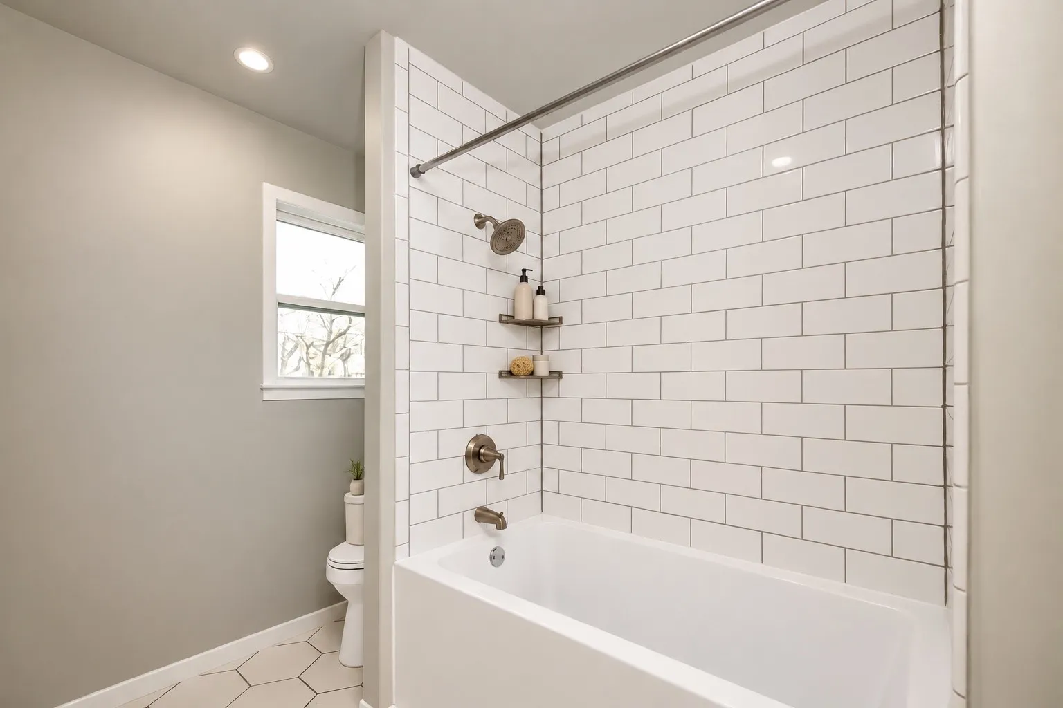 White subway tile shower surround with brushed nickel fixtures, recessed lighting, and hexagonal floor tiling