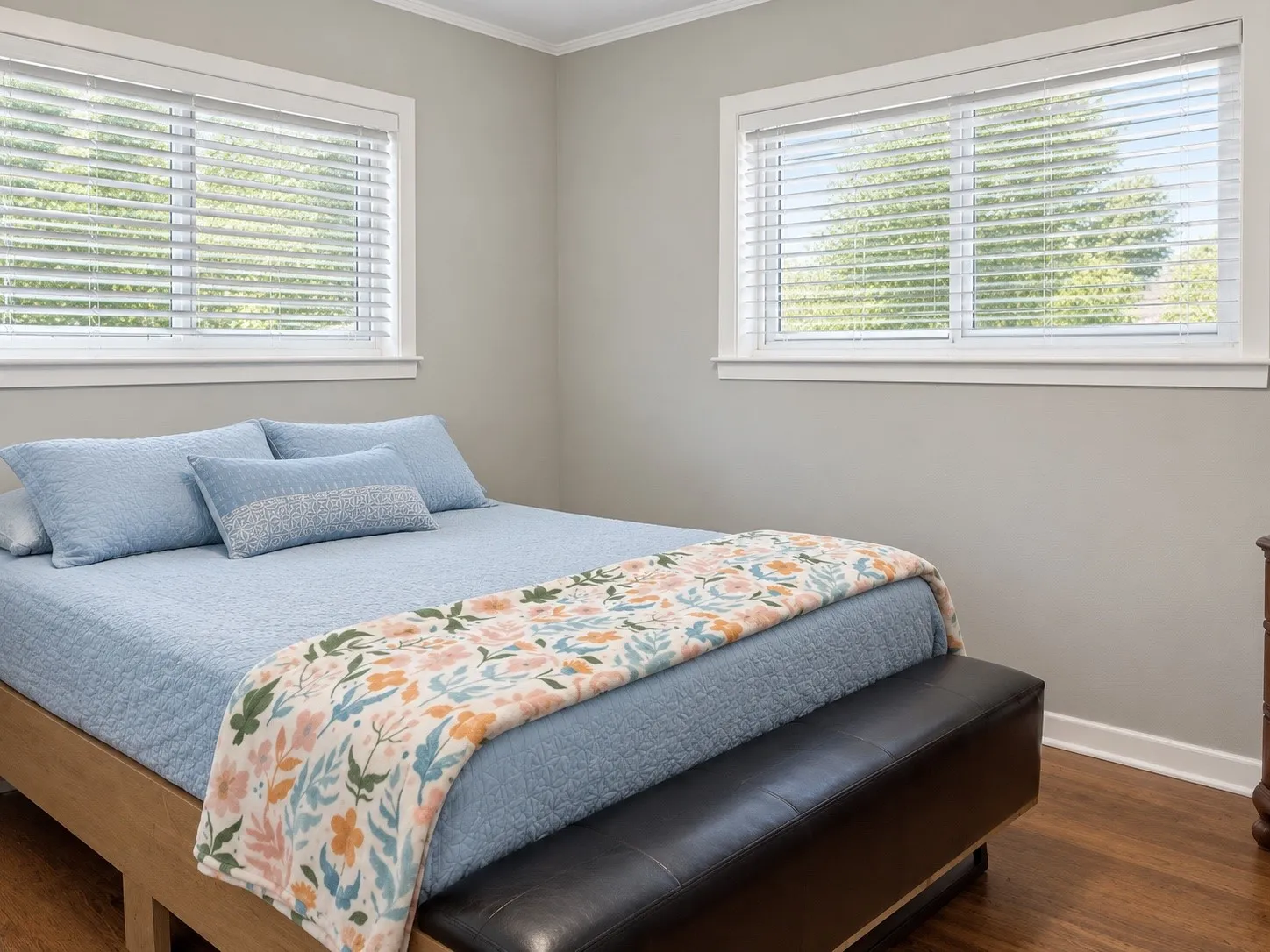 Hardwood-finish flooring, two windows with blinds, and painted walls