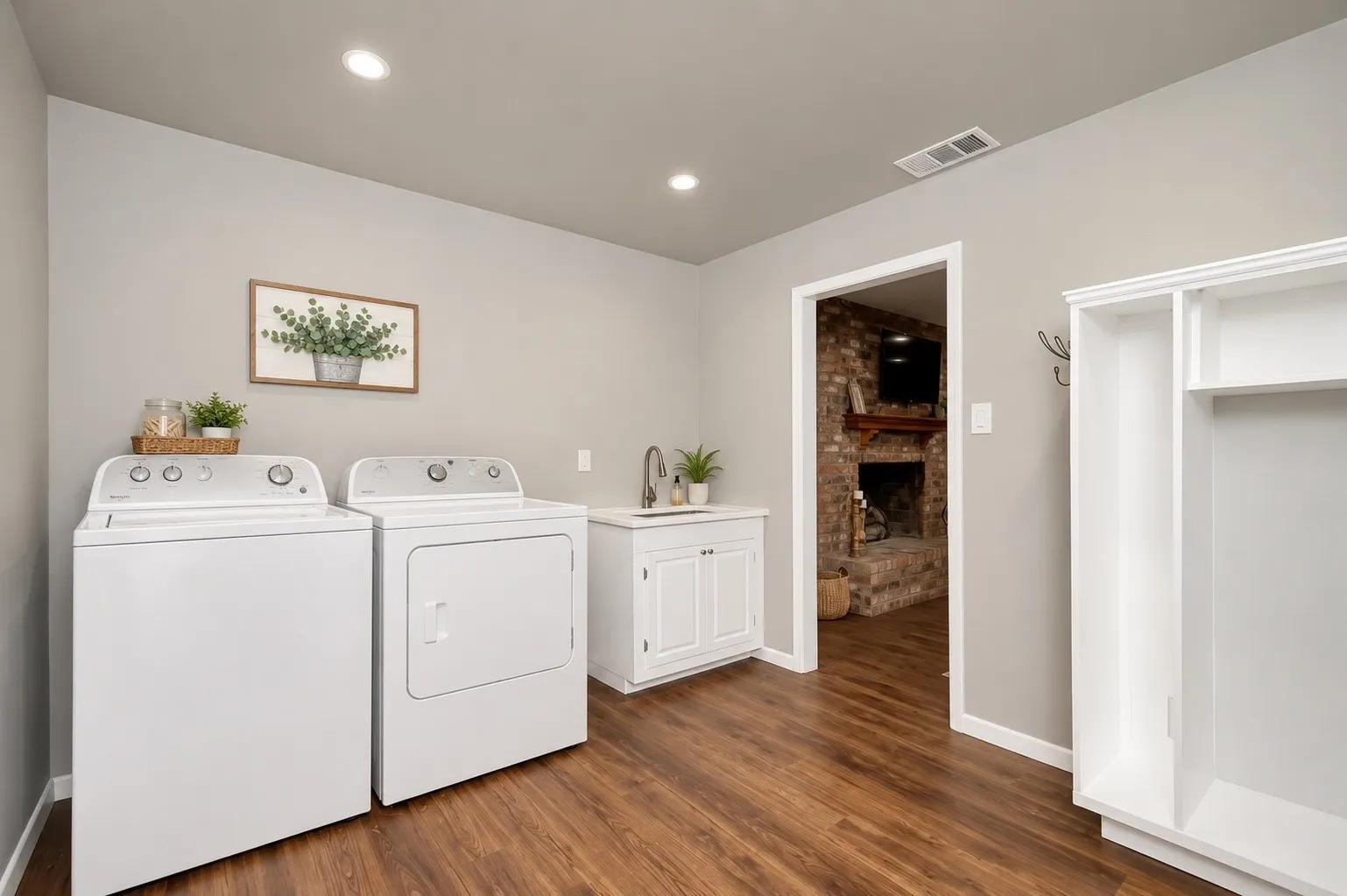 Wood-finish flooring, recessed lighting, white cabinetry, integrated sink, and white built-in storage