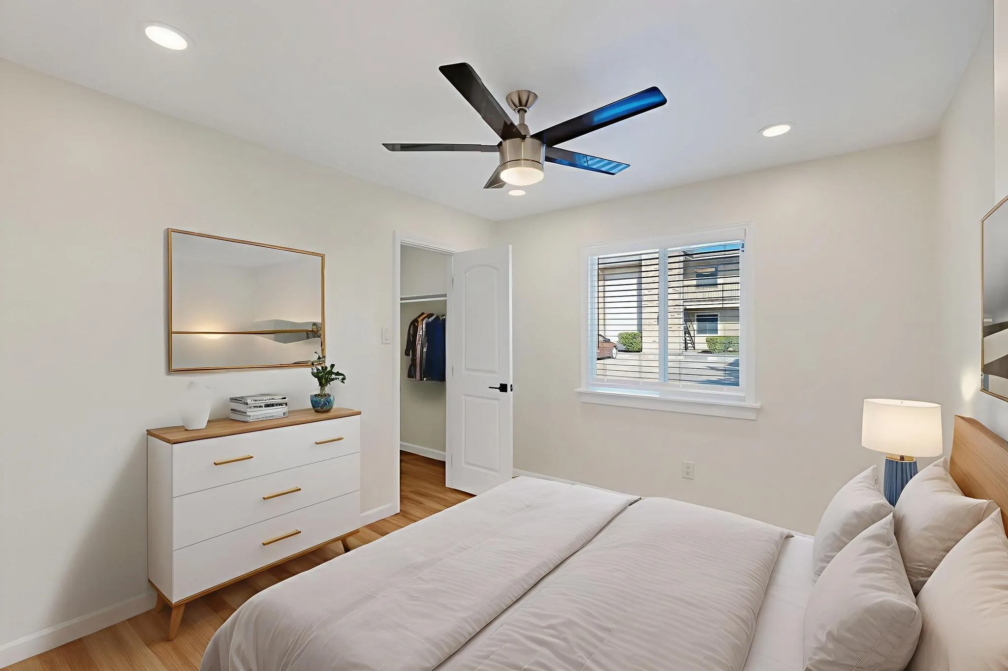 Recessed lighting, wood-finish flooring, ceiling fan with integrated light, ample natural light from a window with blinds, and a built-in closet with an arched doorway