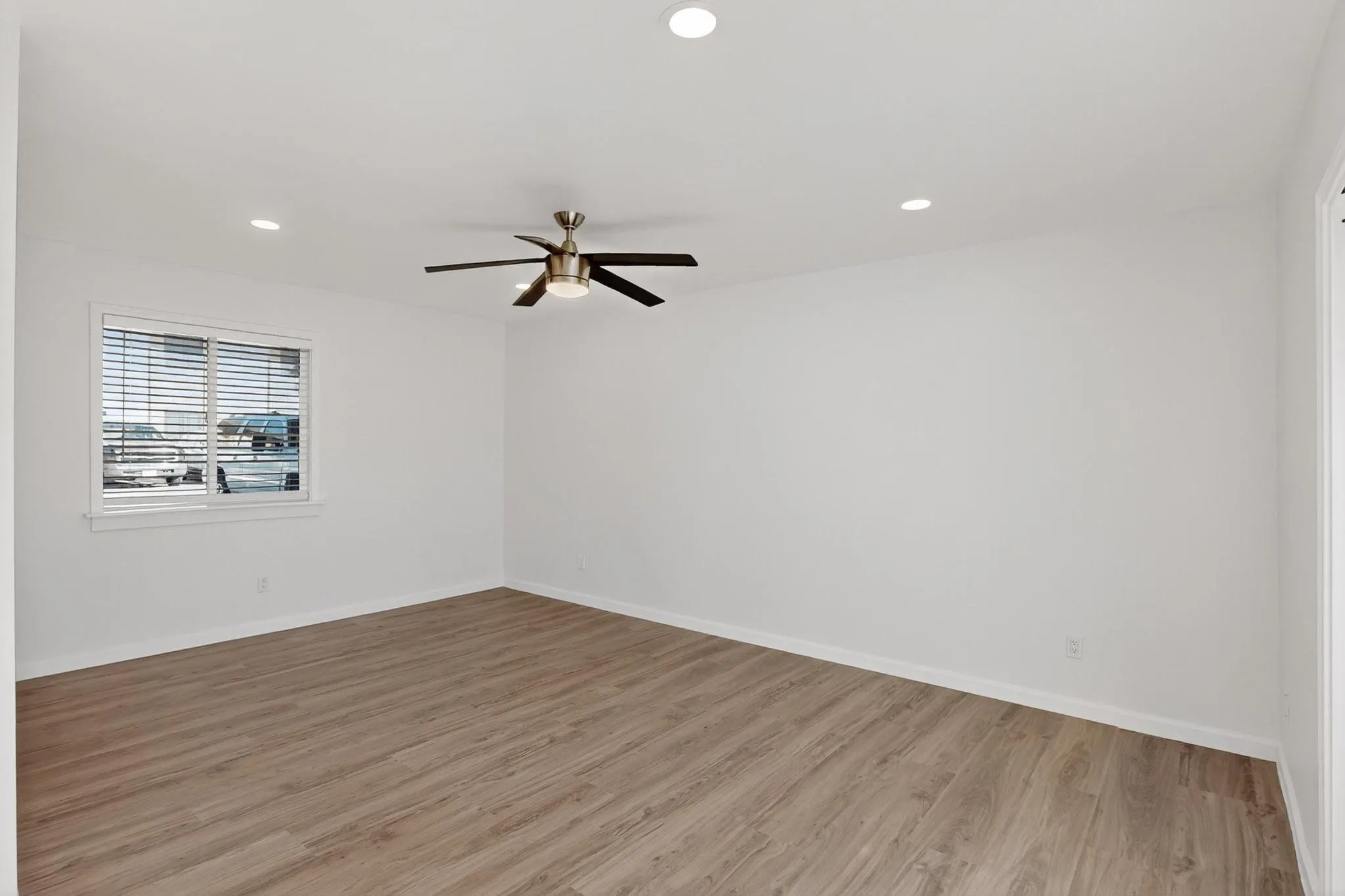 Recessed ceiling lighting, wood-finish flooring, ceiling fan, and window with blinds