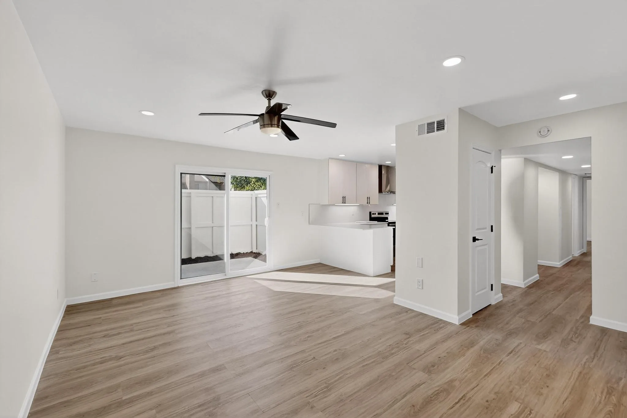 Wood-finish flooring throughout, recessed lighting, and a modern ceiling fan
