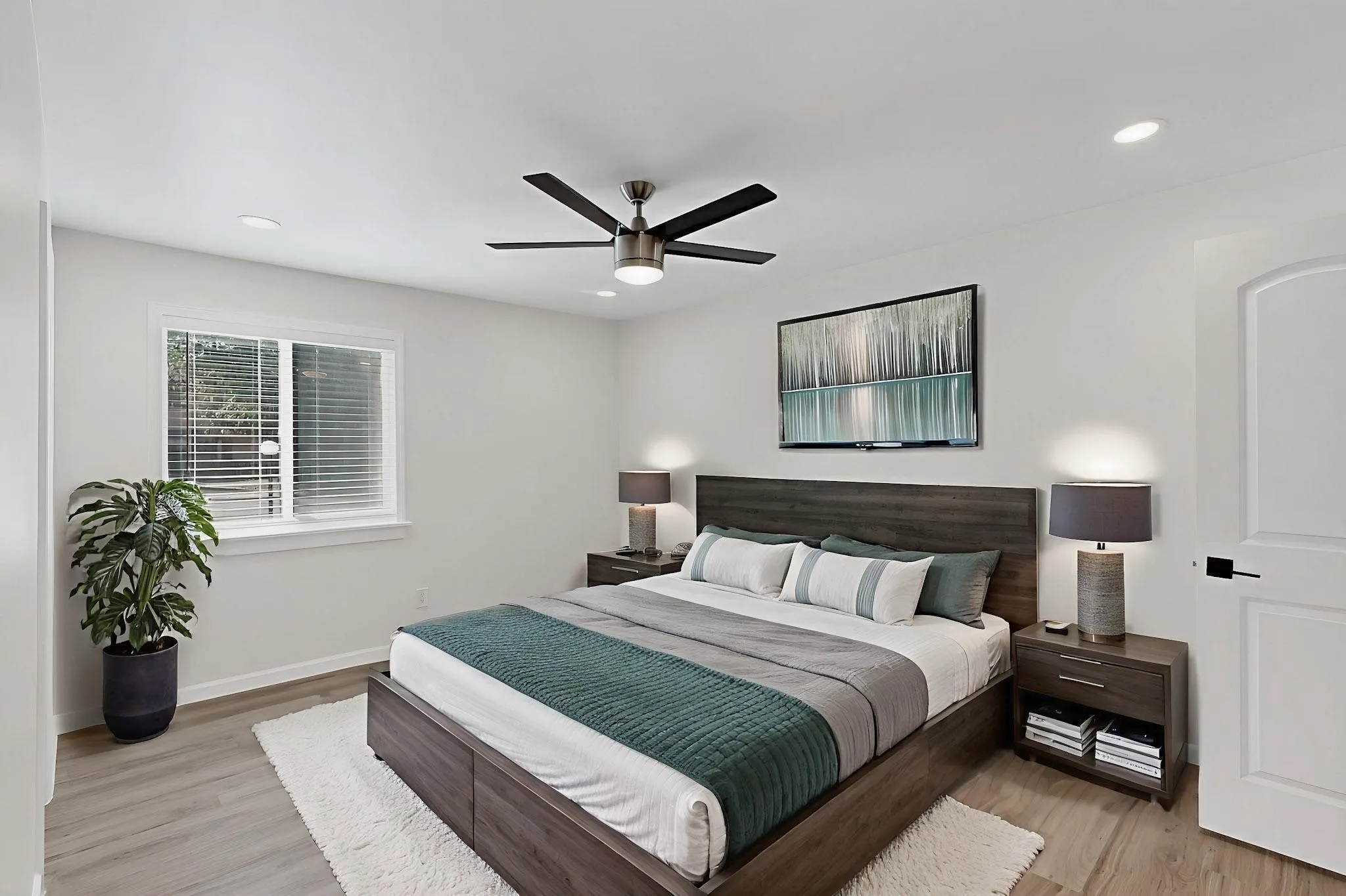 Wood-finish flooring, recessed lighting, ceiling fan with light kit, and a white interior door with dark hardware