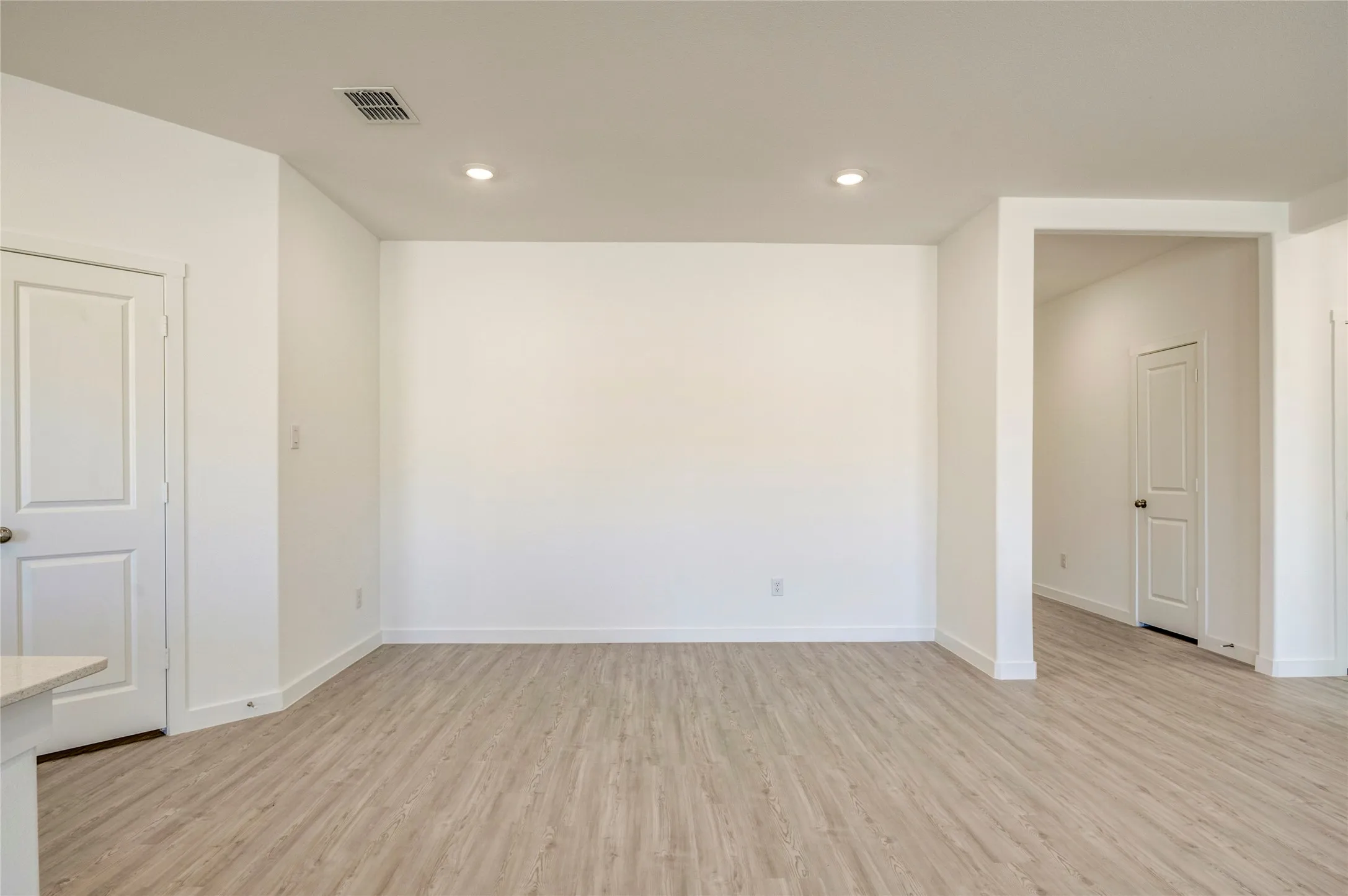 Recessed ceiling lighting, LVP flooring, white painted walls, and white trim throughout....