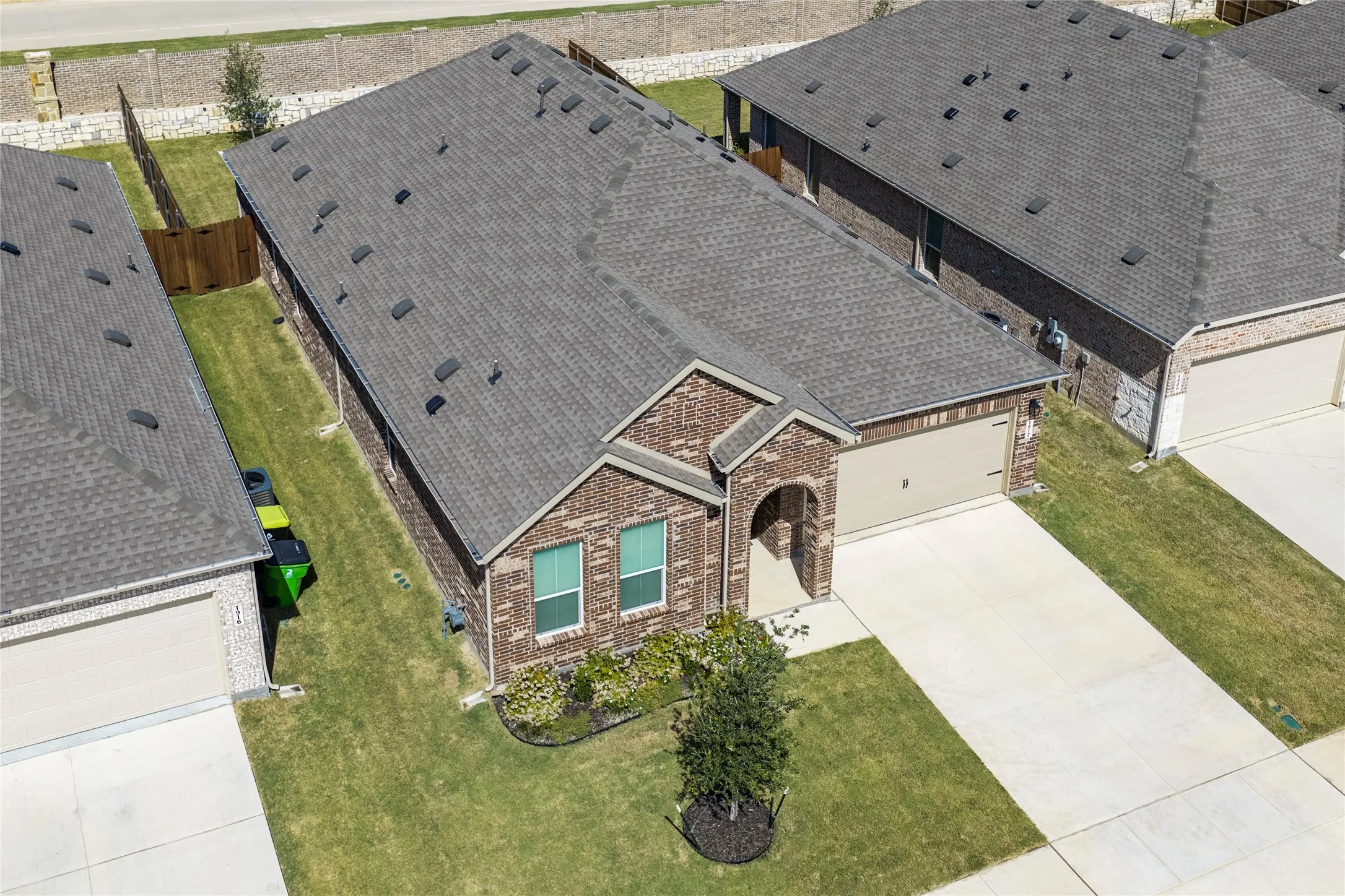 Cute home with attached garage, concrete driveway, and manicured landscaping